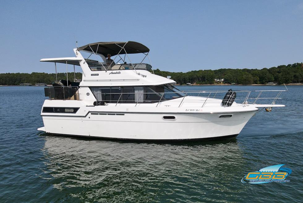 1989 Carver 3807 Aft Cabin yacht cruising on a serene lake.