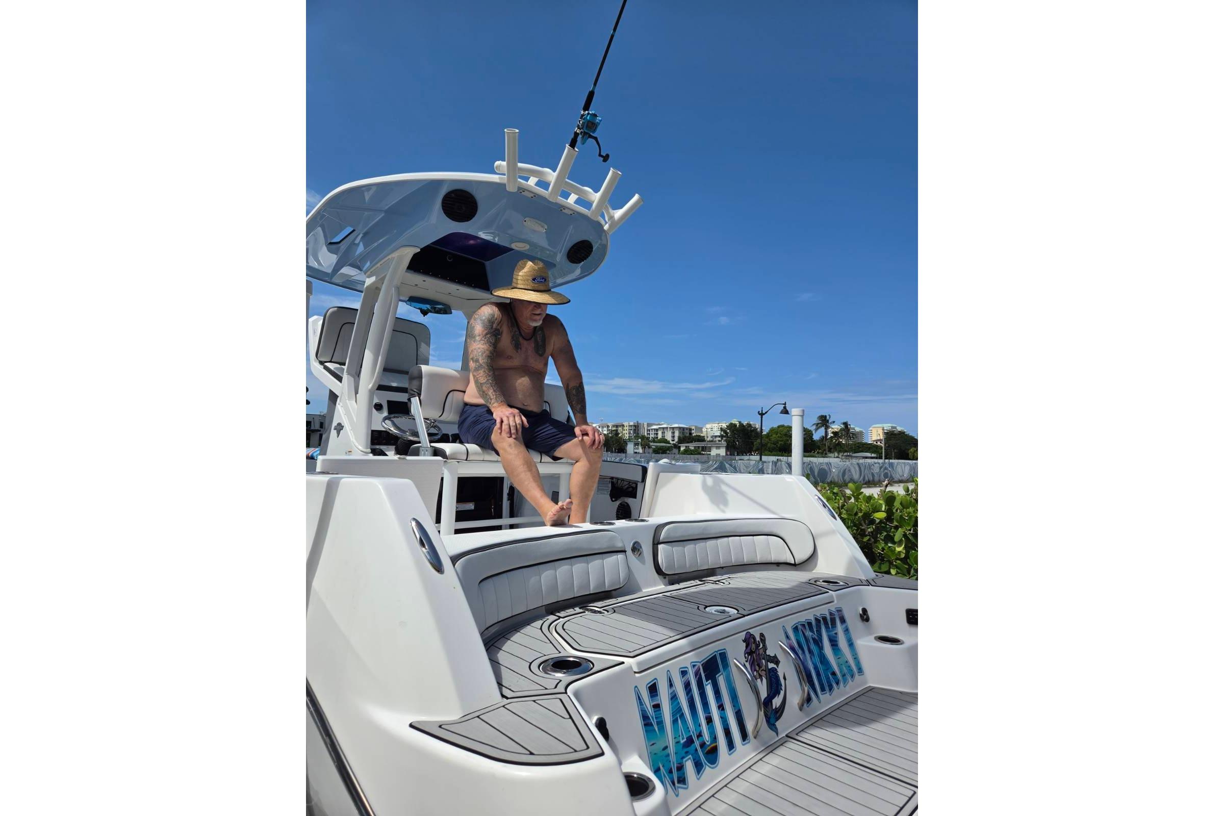 Man relaxing on a 2024 Yamaha Boats 222 FSH Sport E, sunny day.