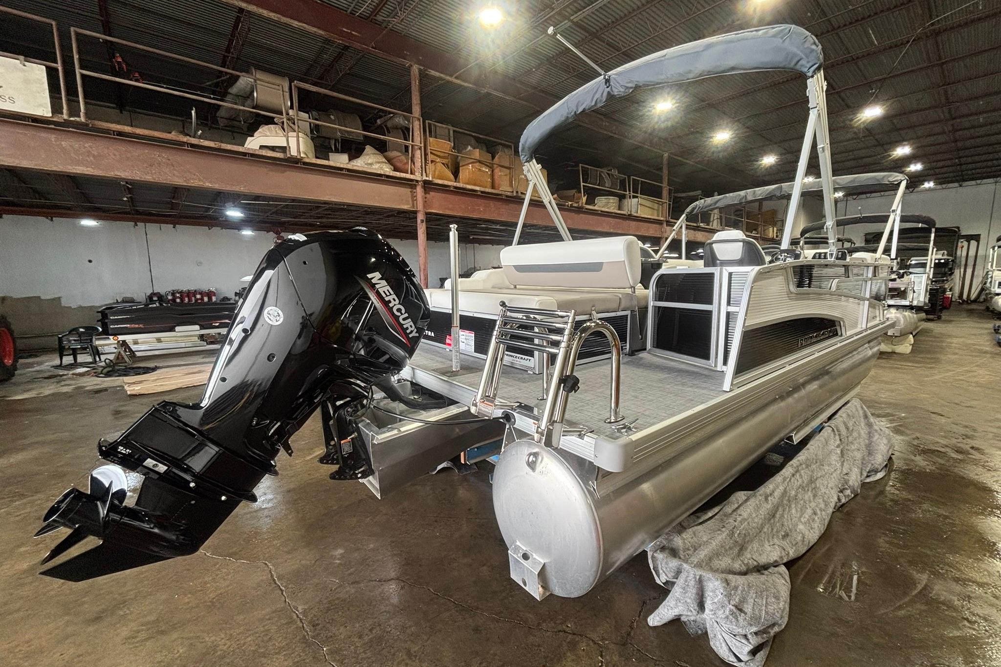 2025 Princecraft Vectra 21 RL pontoon boat with Mercury outboard motor in a warehouse.