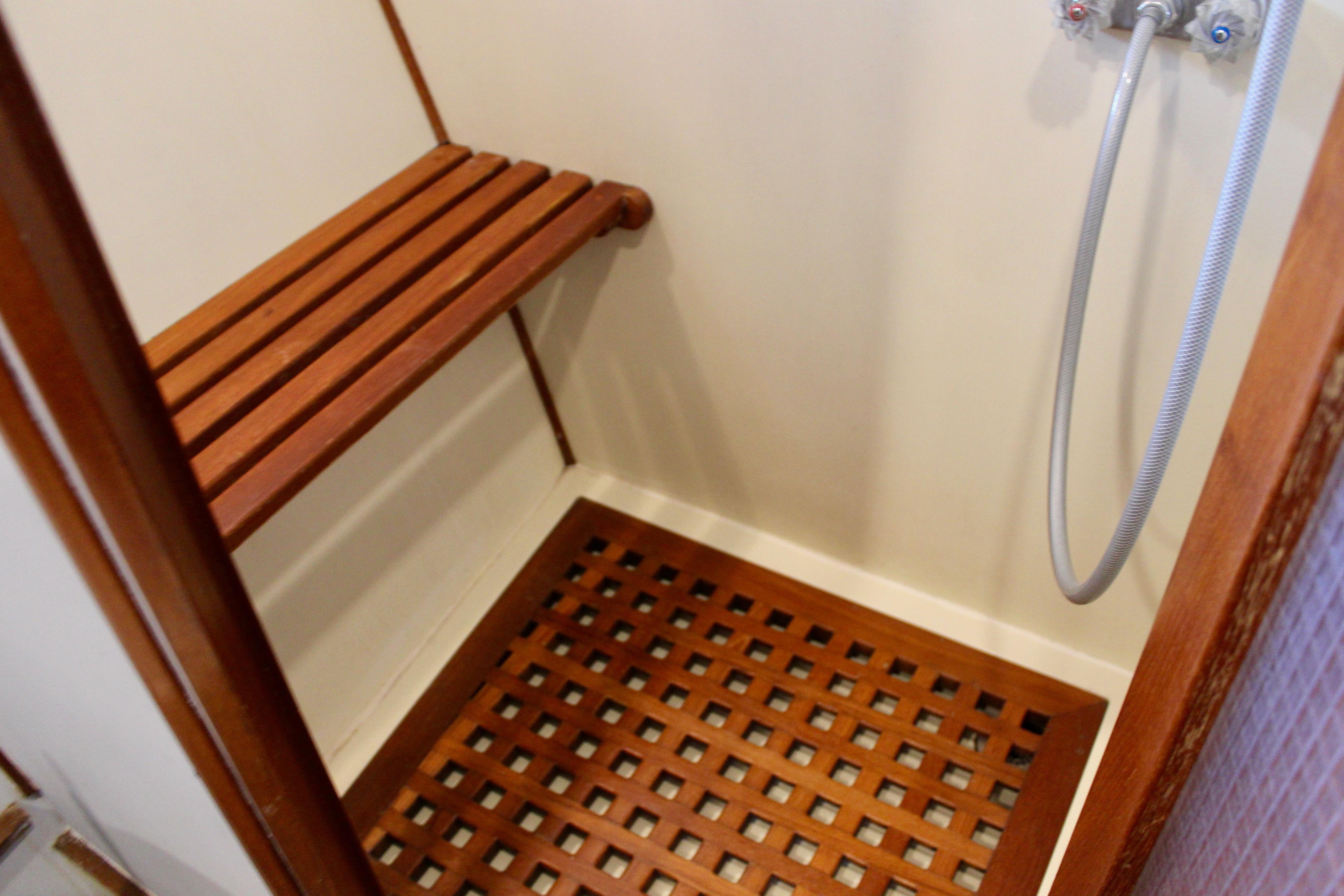 Shower area in 1986 Kha Shing Spindrift 46 yacht with wooden bench and floor.