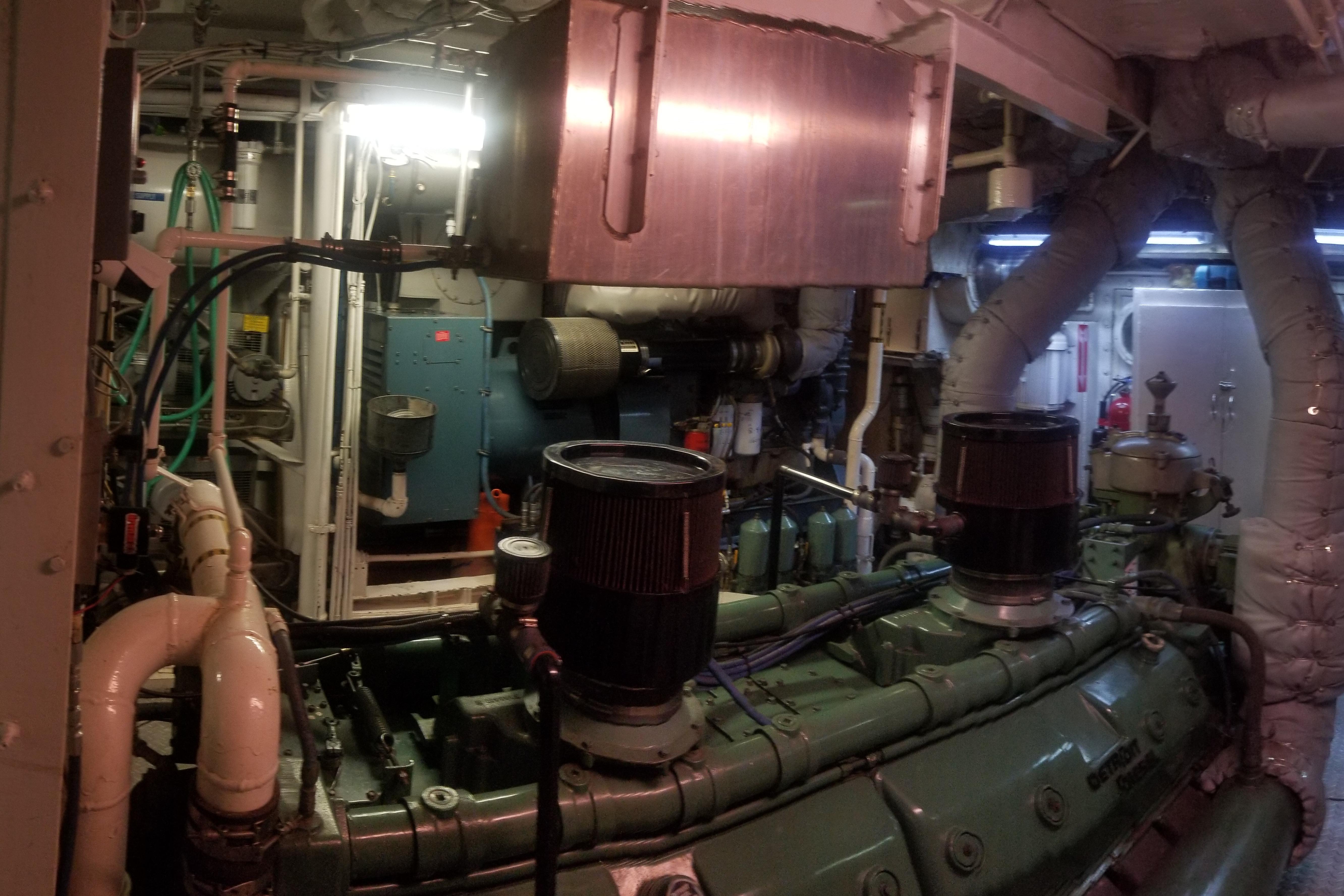 Engine room of a 1974 Custom Steel Cannery Tender, showcasing machinery and piping.