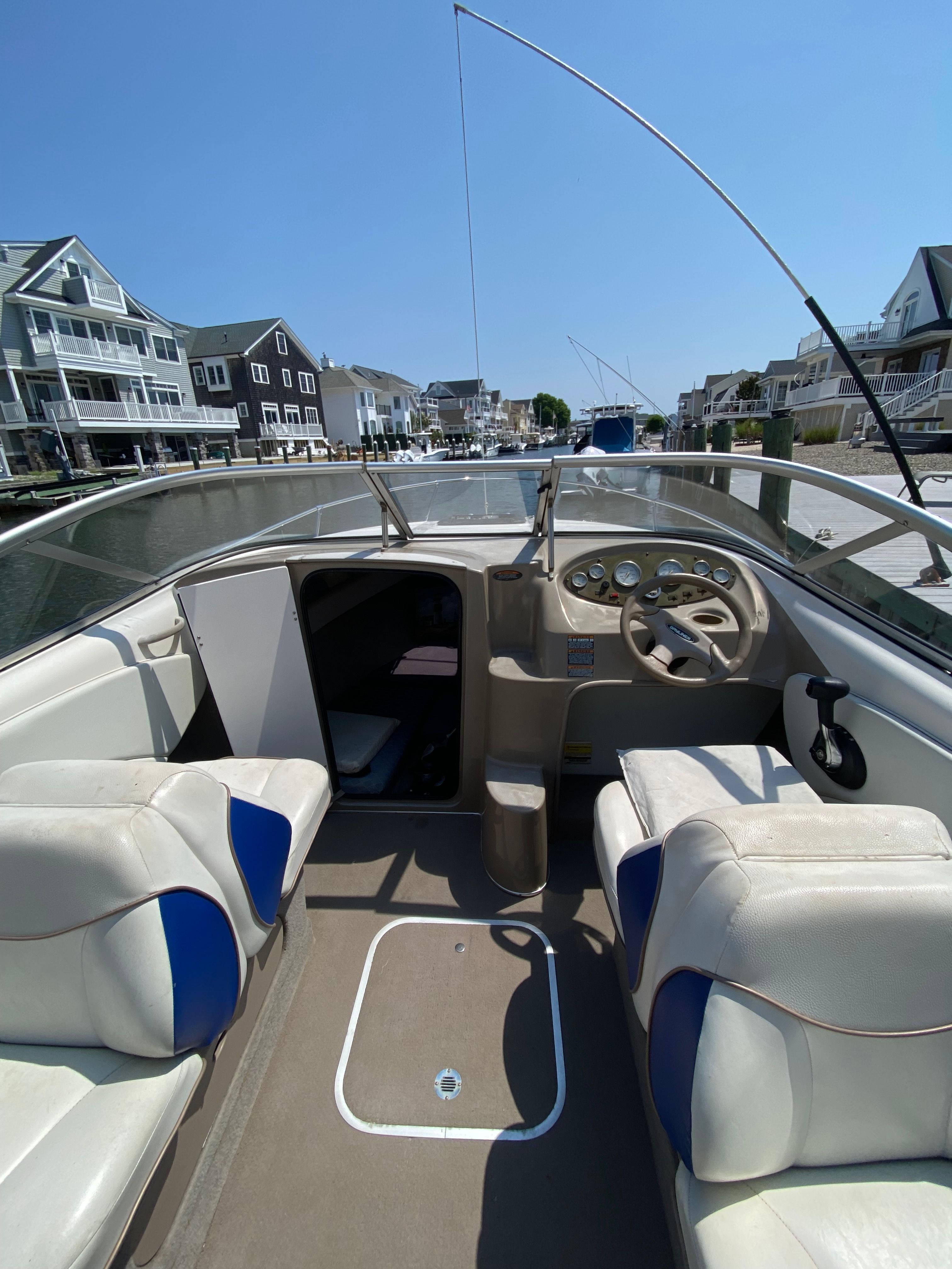 The image shows the cockpit of a 2003 Bayliner 2152 boat with two seats and a steering wheel.