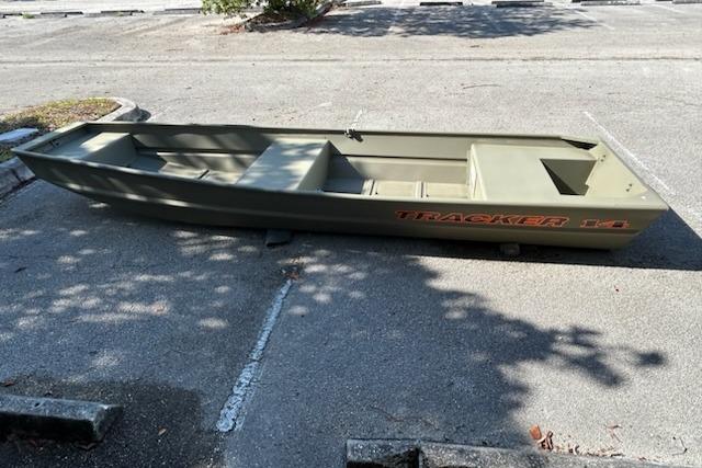 2026 Tracker Grizzly 14 Jon boat parked on pavement, showcasing its sturdy design.