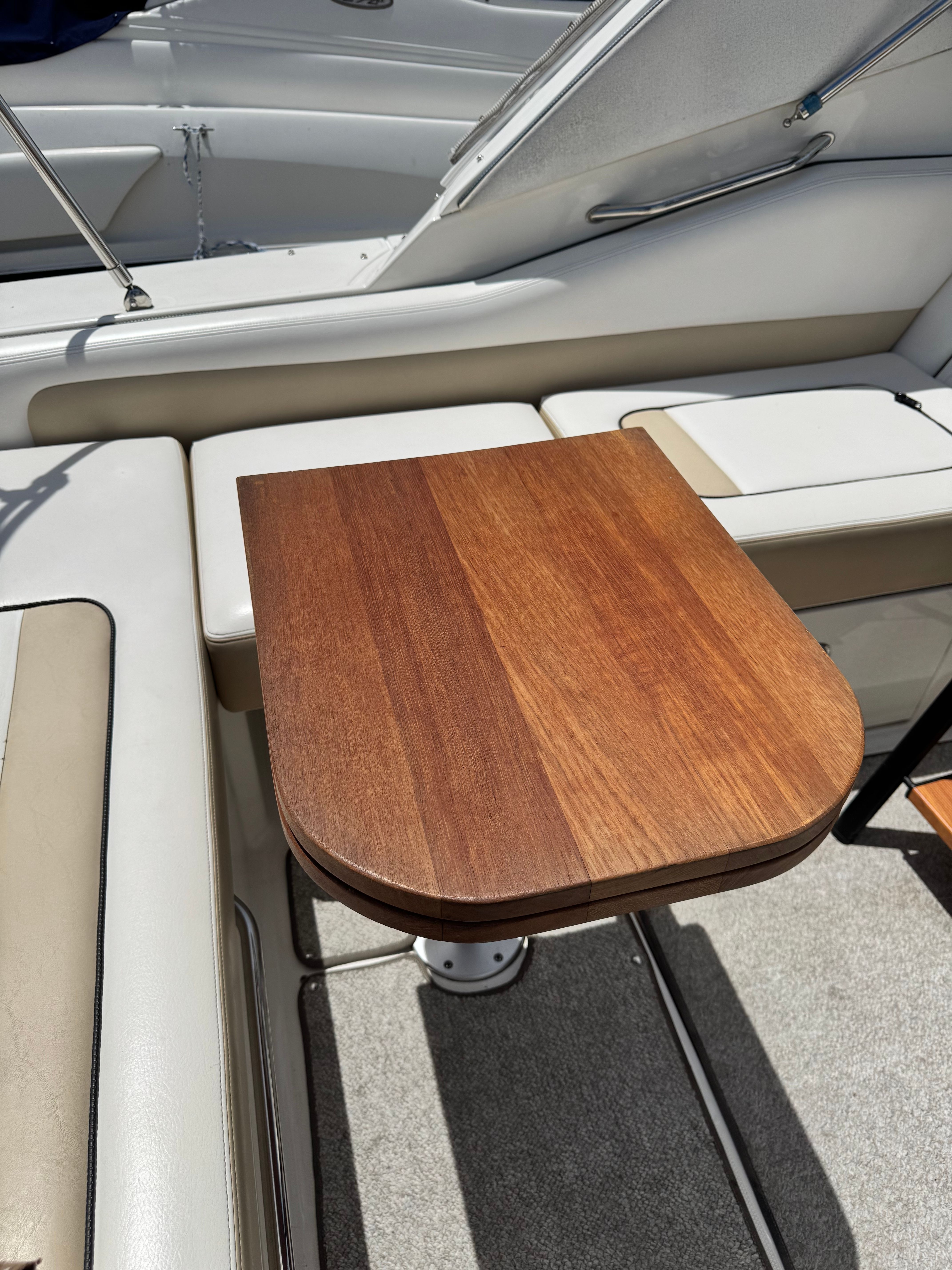 A sleek wooden table on a 2010 Sea Ray Sundancer 310 boat.