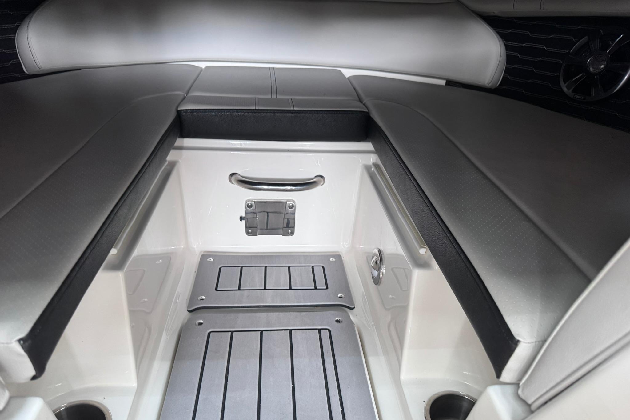 Interior of 2021 Sea Ray SPX 230 boat, featuring sleek seating and storage area.