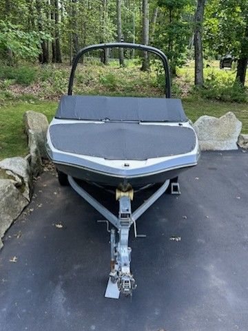 A 2019 Yamaha AR195 boat on a trailer in a wooded area.