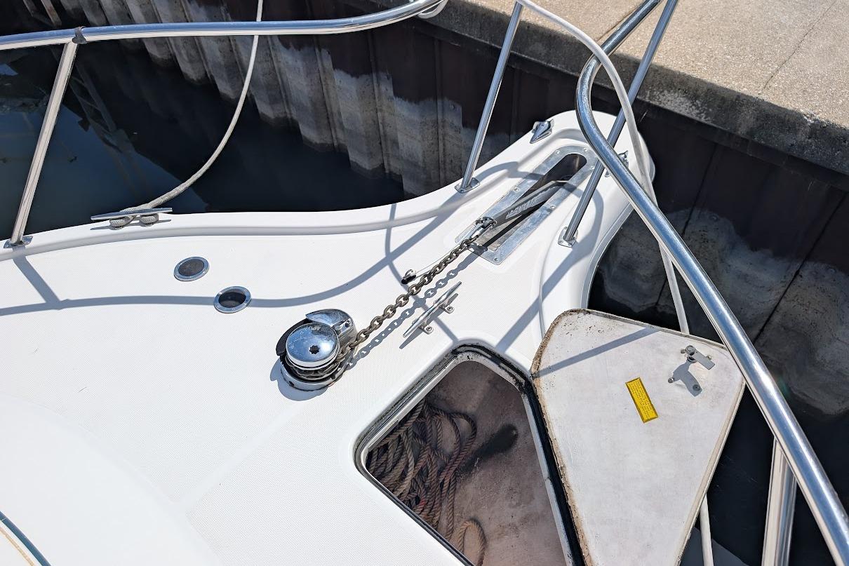 Bow of a 2000 Pursuit 3400 Express boat with anchor chain and storage compartment.