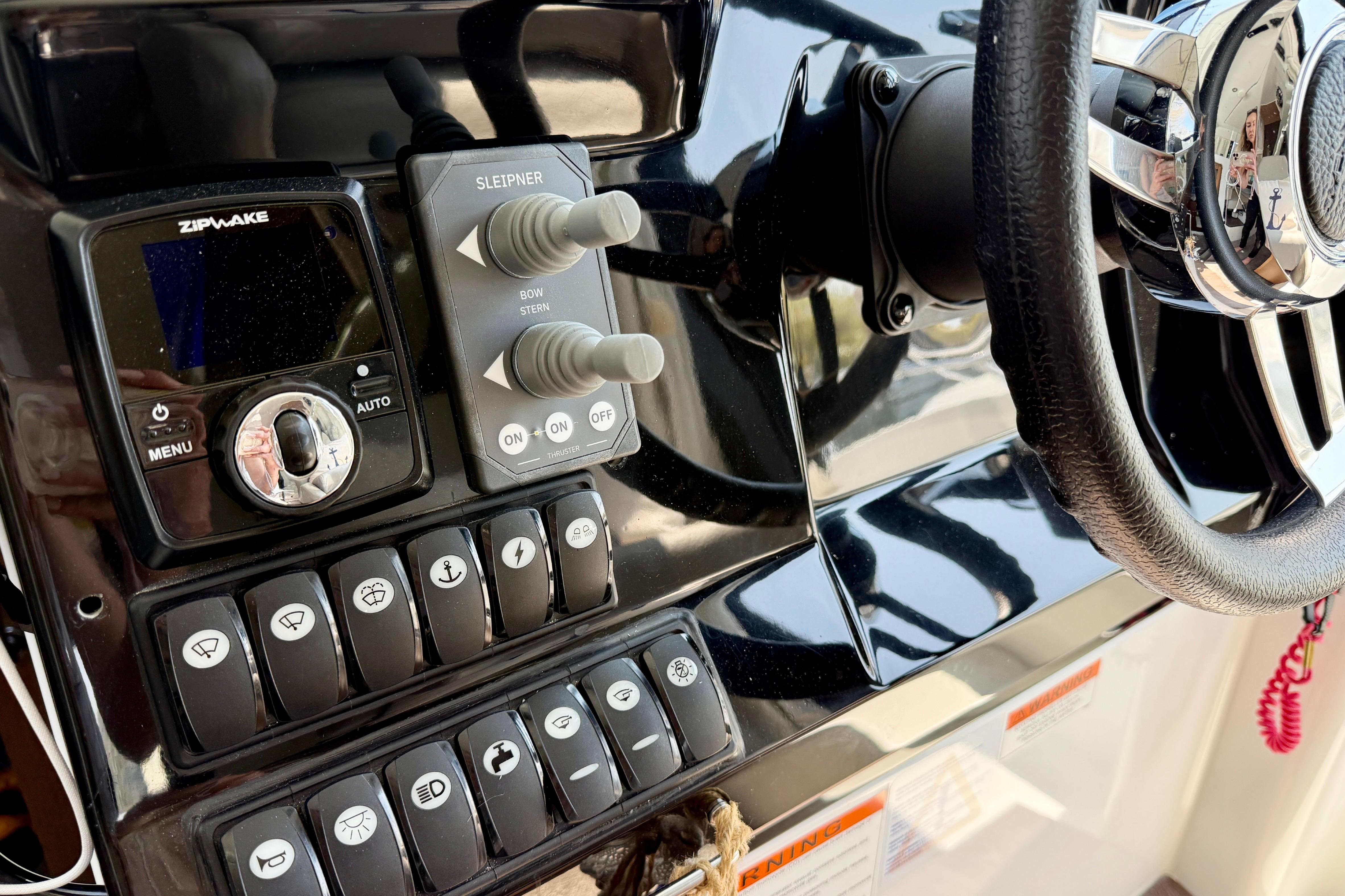 Control panel of a 2022 Jeanneau NC 1095 Fly boat with steering wheel.