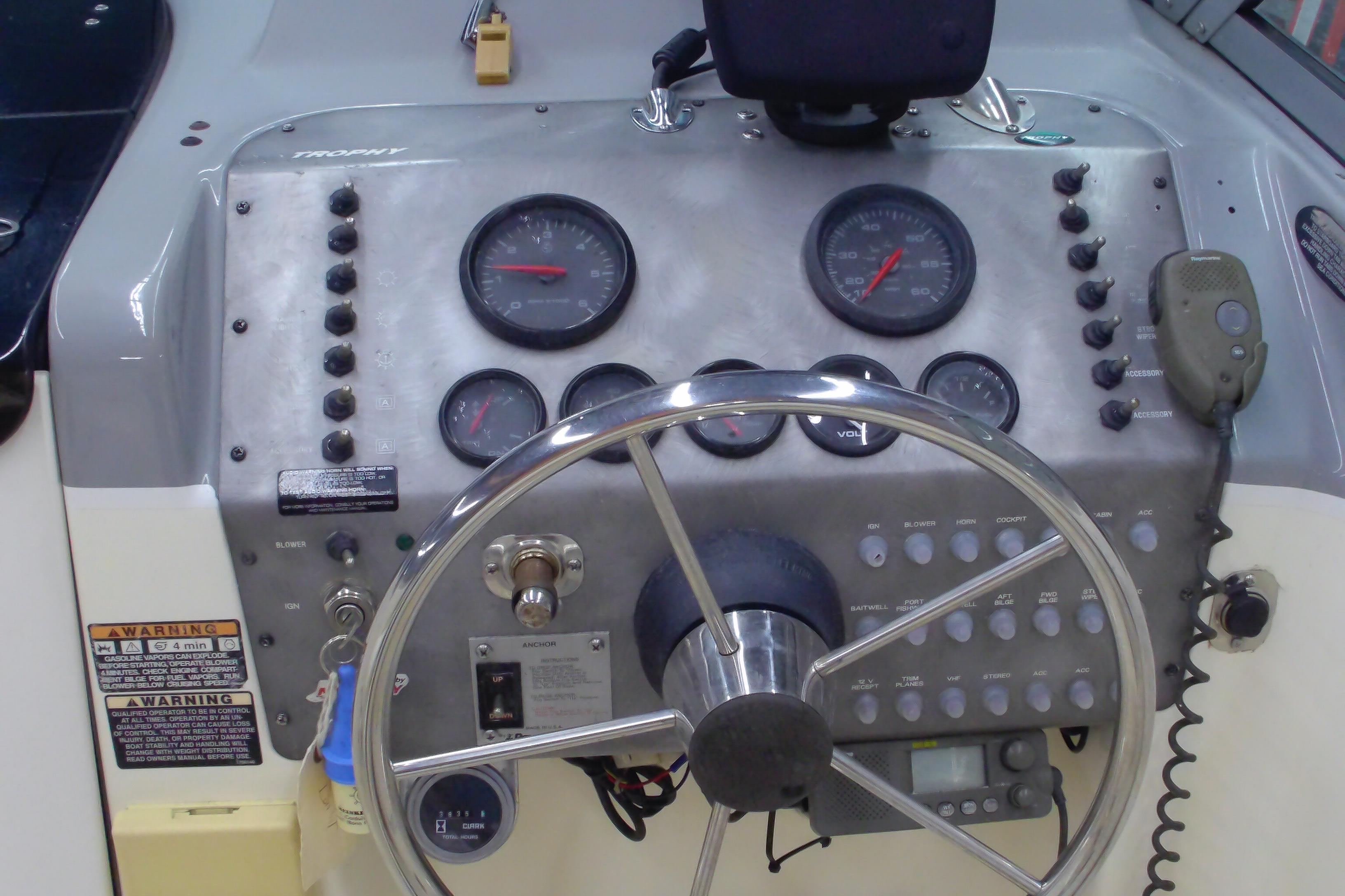 Control panel of a 2004 Trophy 2352 Walkaround boat with steering wheel and gauges.