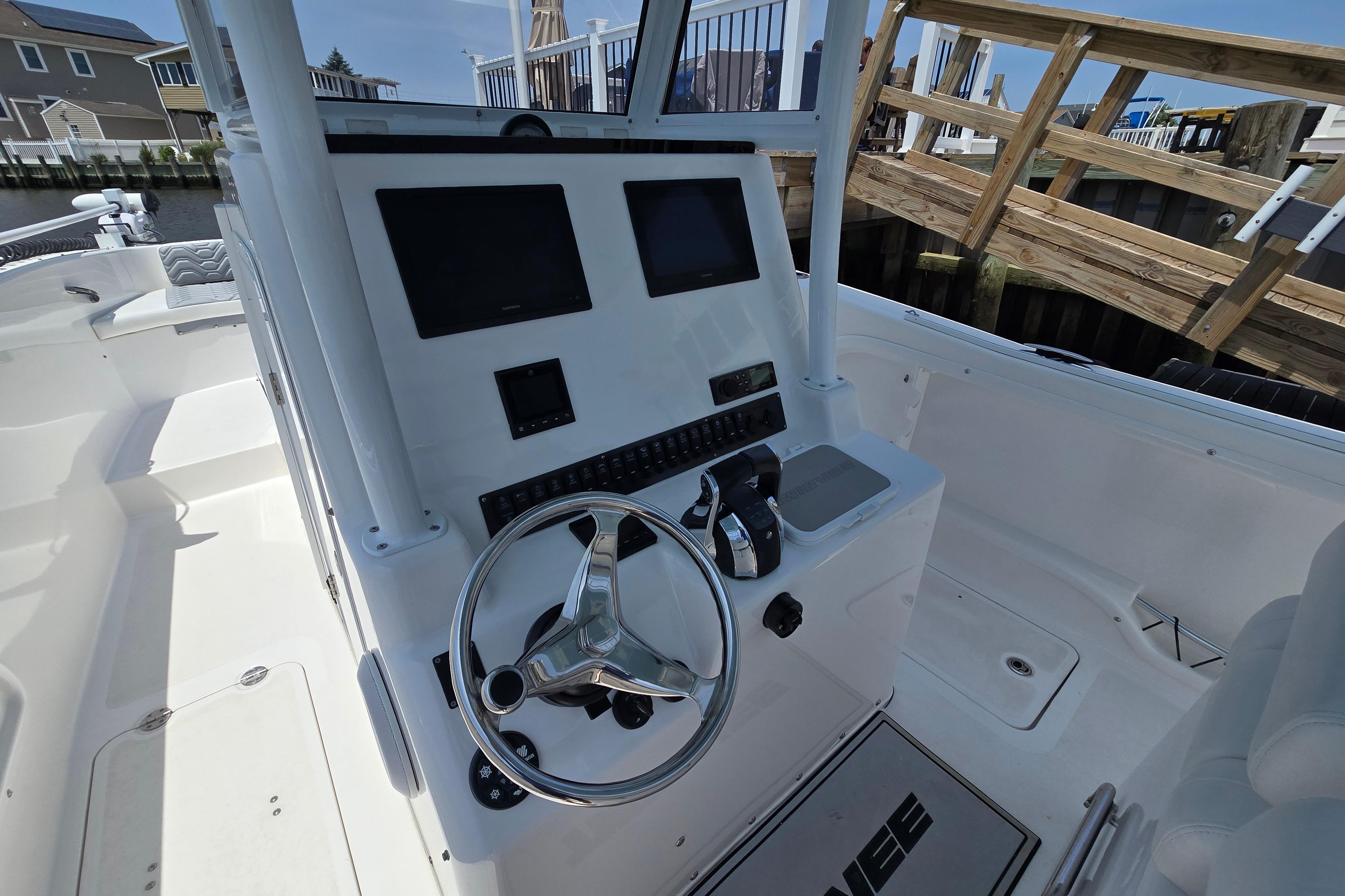 2021 Twin Vee 280 GFX CC boat cockpit with steering wheel and control panel.