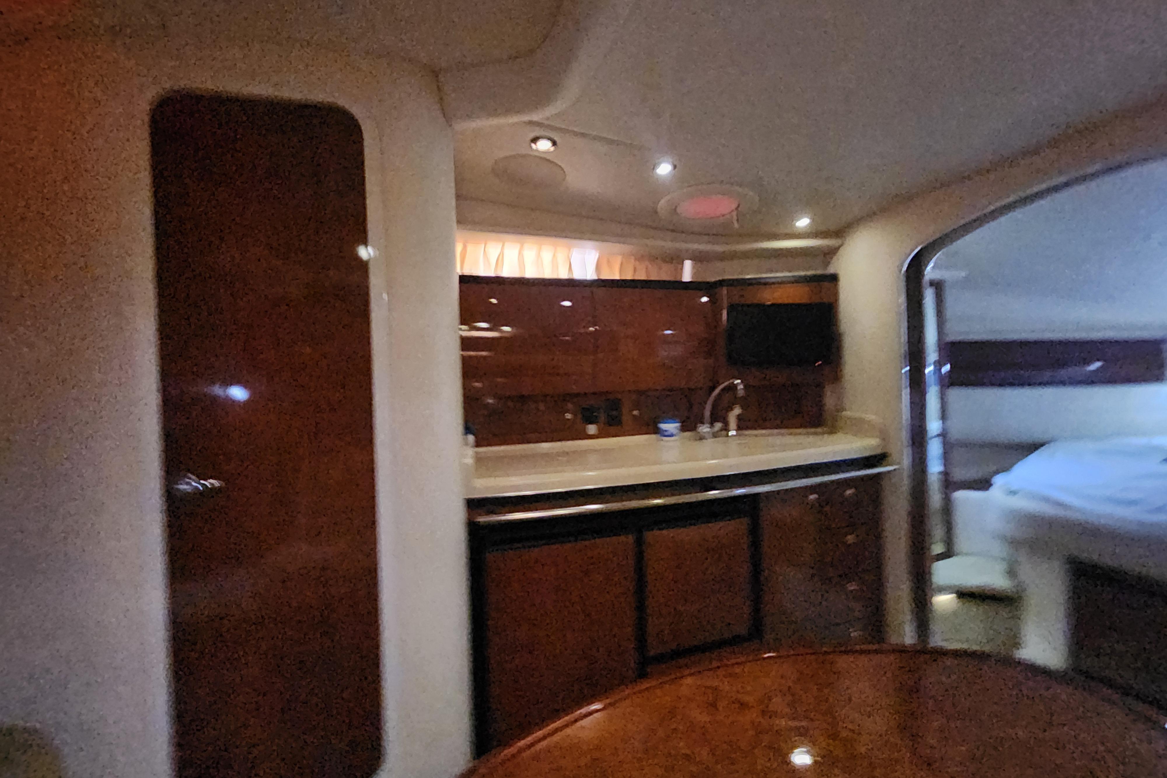 Interior of 2003 Sea Ray 360 Sundancer yacht with kitchenette and cozy cabin.