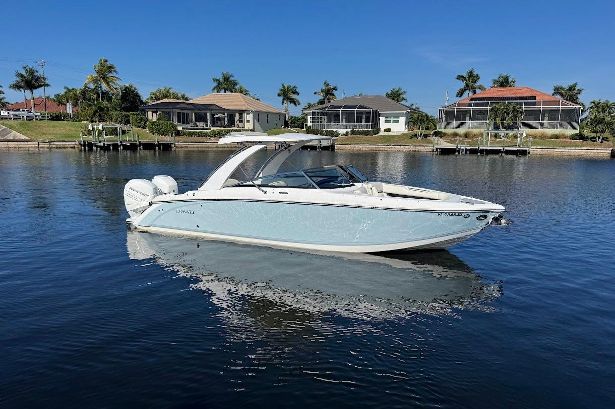 2018 Cobalt 30SC boat on calm water, with waterfront homes and palm trees in the background.