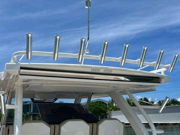 2019 Pursuit S 408 Sport boat with rod holders under a clear blue sky.