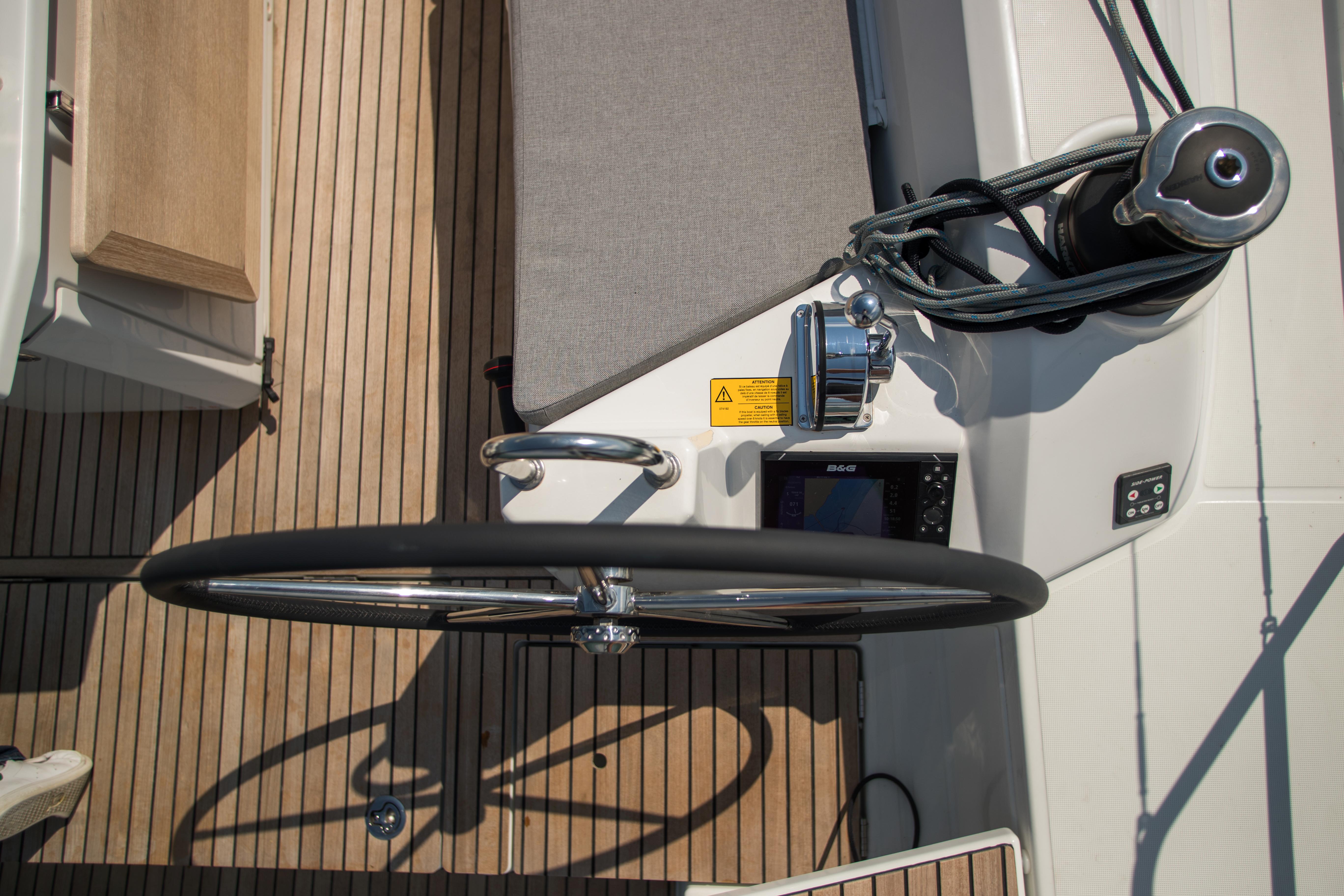 2025 Beneteau Oceanis 40.1 yacht helm with wooden deck and navigation equipment.