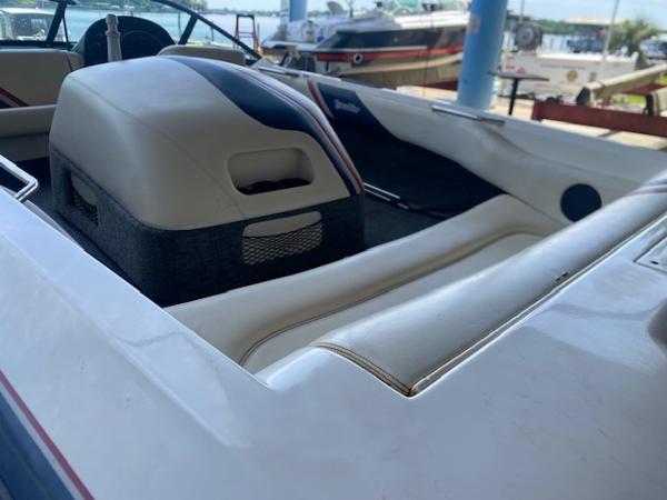 1998 Malibu Response boat interior with white seating and engine cover, docked near water.
