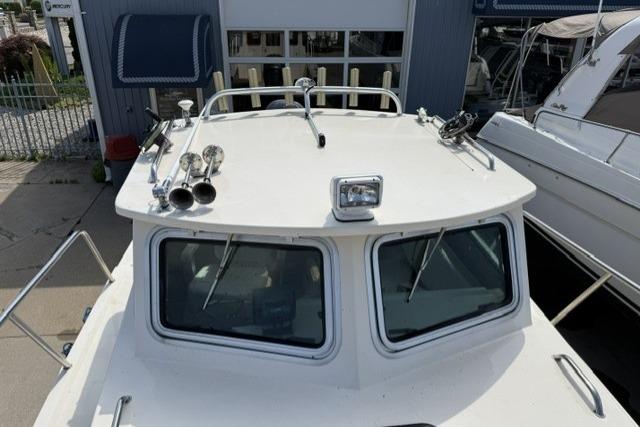 2006 Parker 2520 SL Sport Cabin boat docked, showcasing cabin roof and windows.