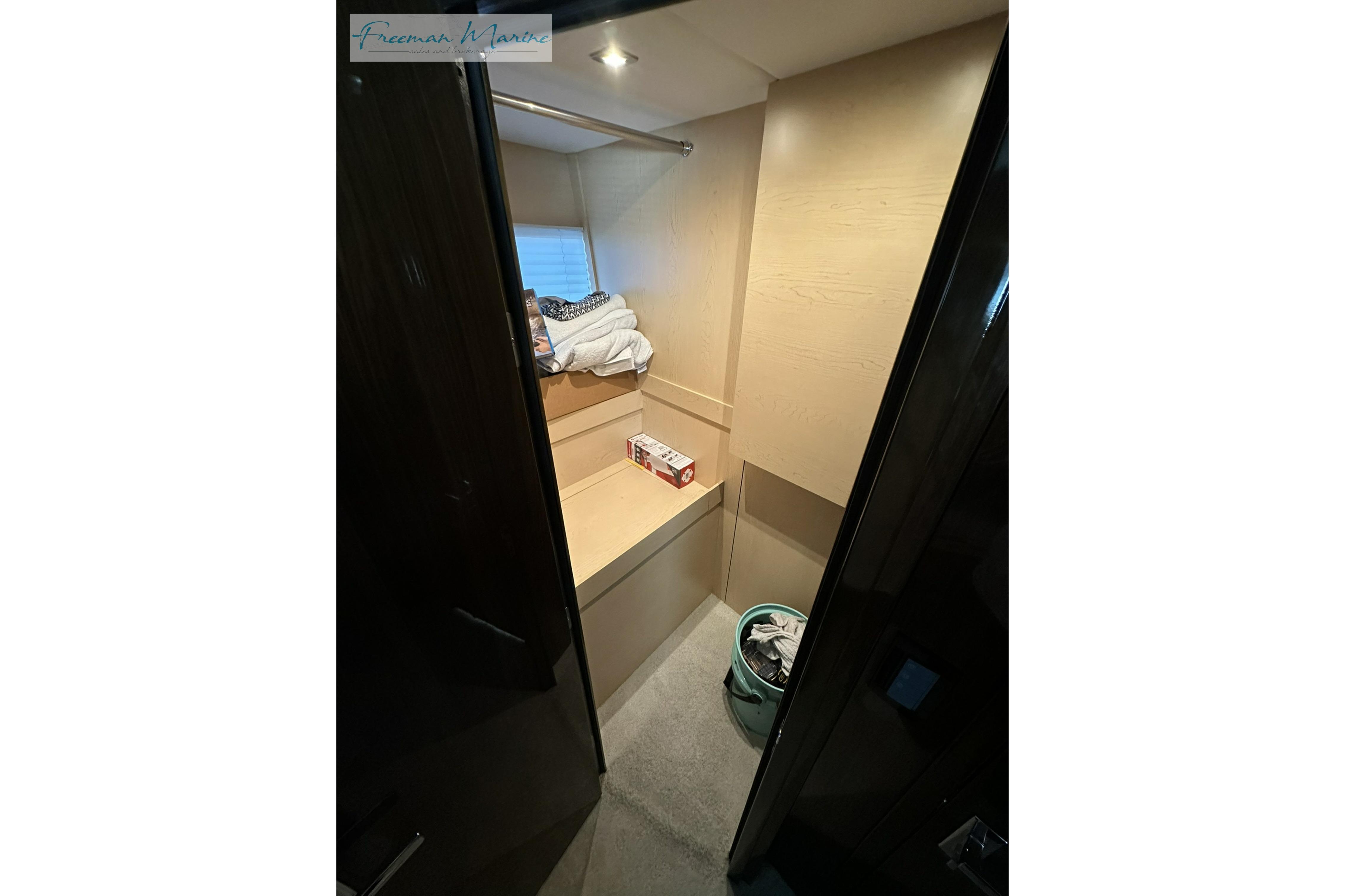 Interior view of 2022 Cruisers Yachts 60 Cantius cabin with storage and laundry basket.