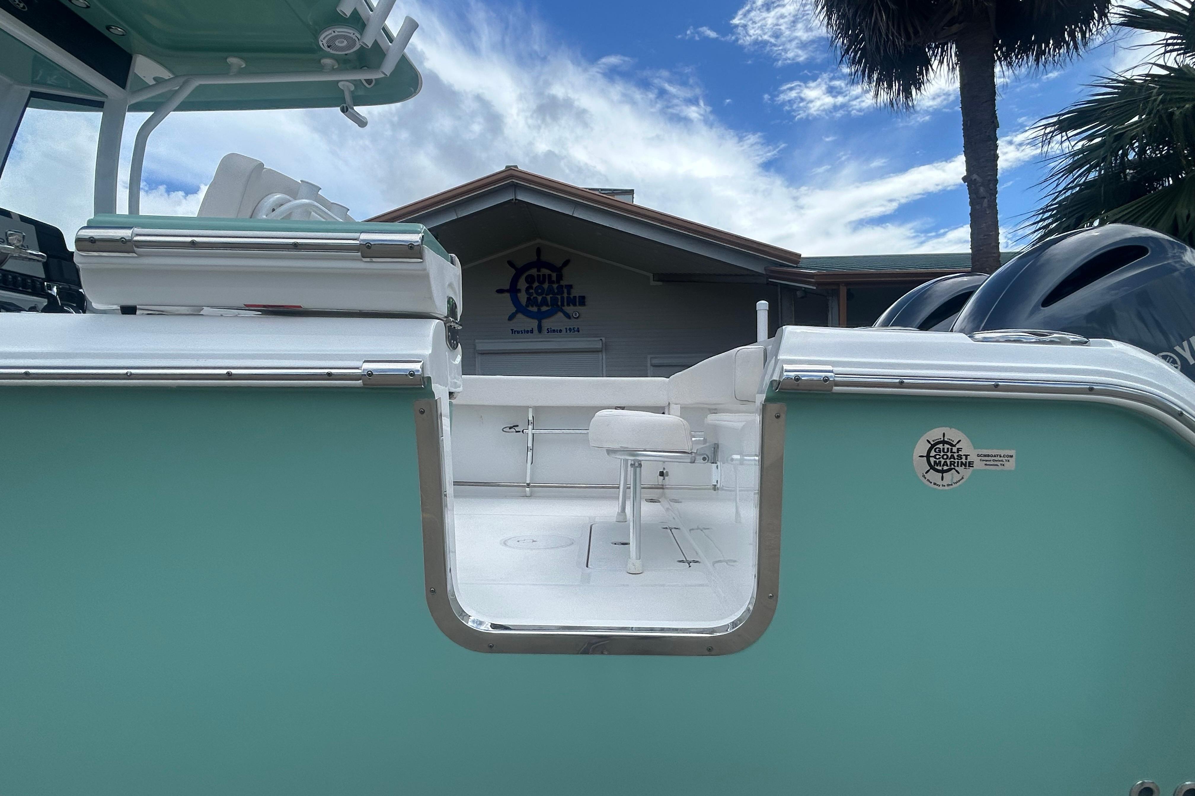 2023 Sea Hunt Gamefish 27 Coffin Box boat, mint green exterior, docked under blue sky.