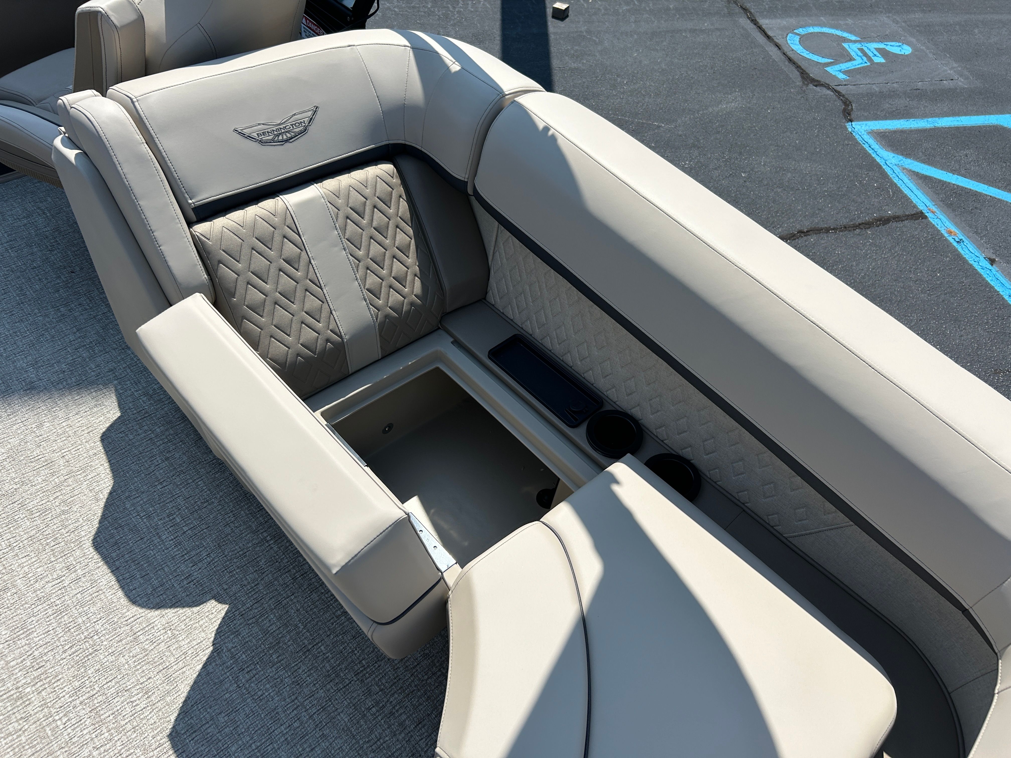 The image shows a beige bench seat on a boat with quilted pattern and cup holders.