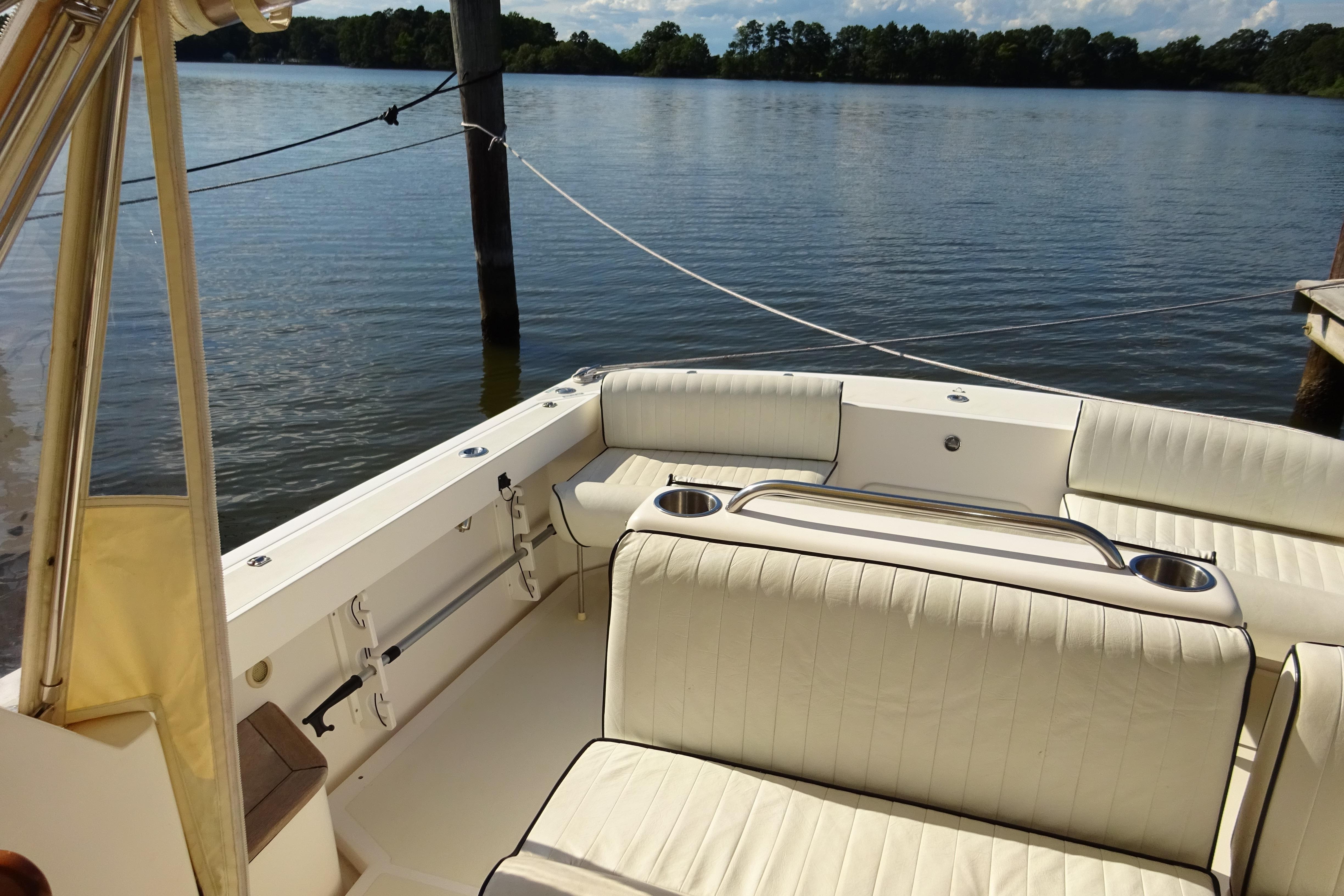 2007 Hunt Yachts Surfhunter 29 interior with white seating, docked by a serene lake.