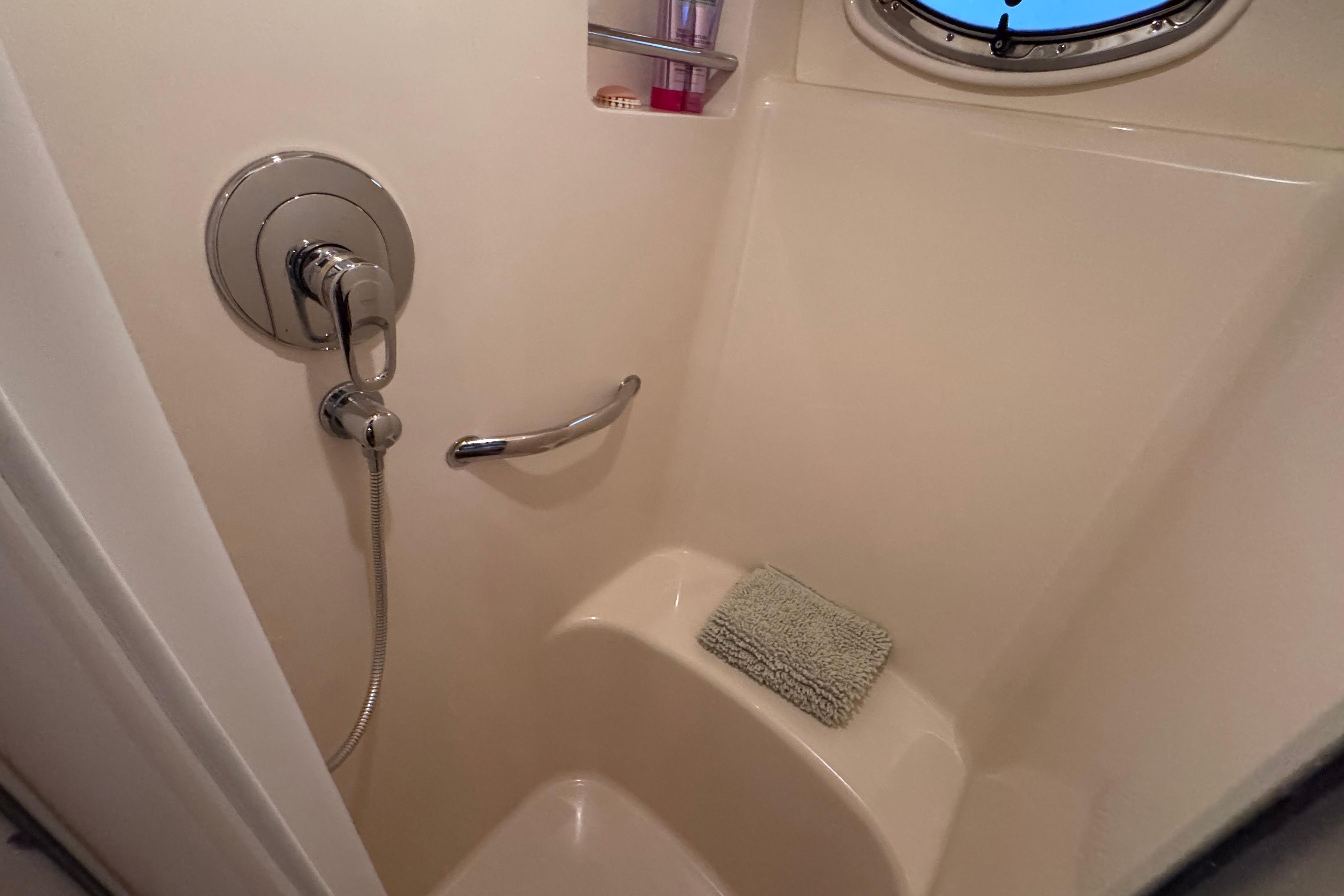 Shower area in 2004 Sea Ray 390 Motor Yacht with chrome fixtures and porthole window.