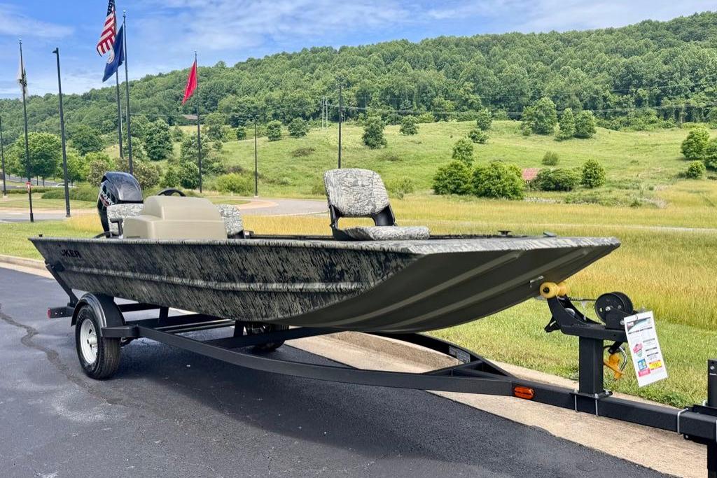 2026 Tracker Grizzly 1754 SC boat on trailer, parked outdoors with scenic background.