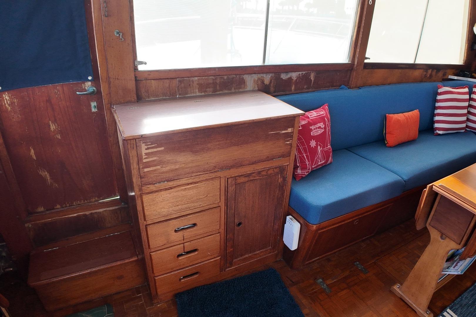 Interior of 1978 Grand Banks 42 Classic with wooden cabinetry and blue seating.
