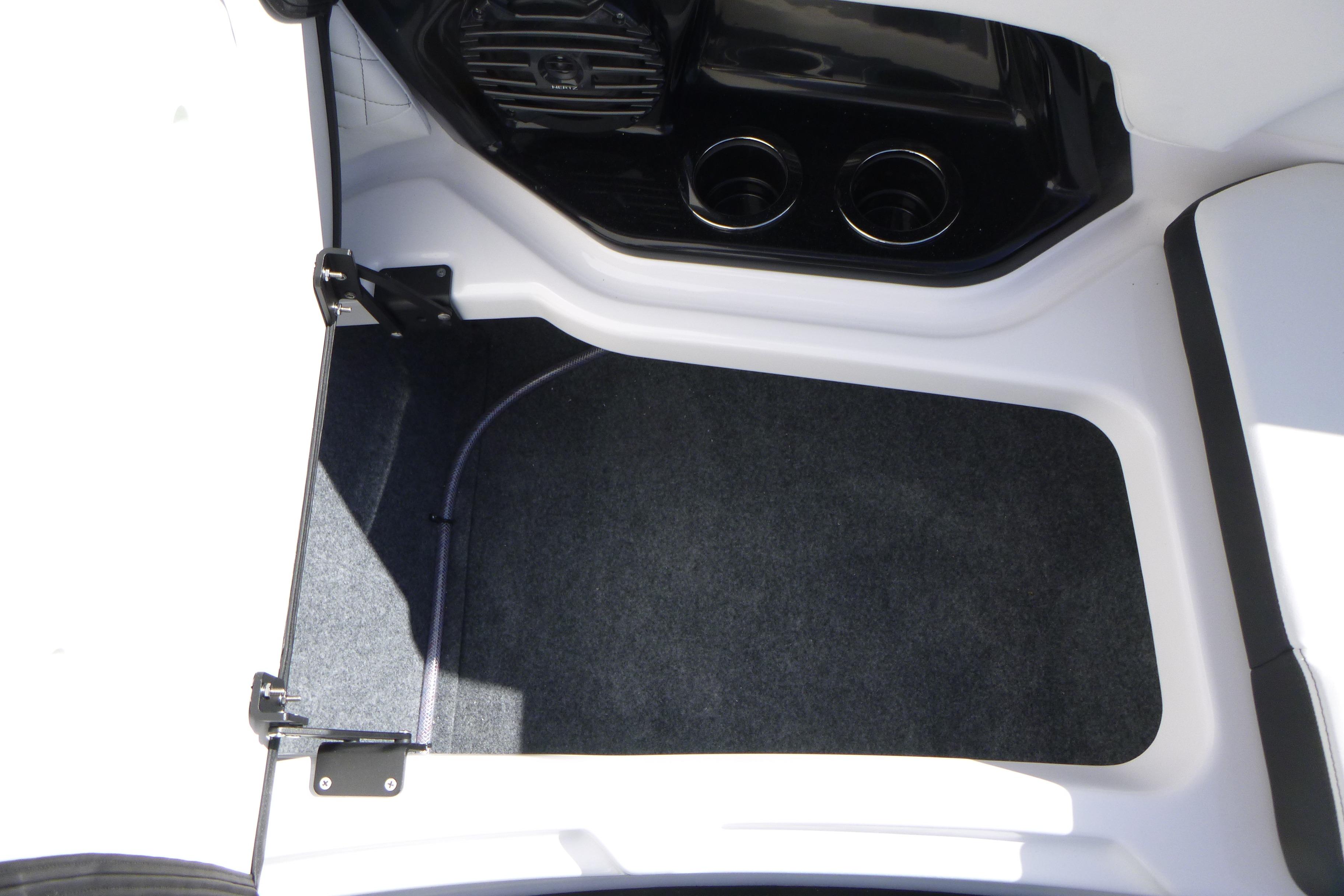 2026 Yamaha Boats 252SD interior storage compartment with cup holders and carpeted flooring.