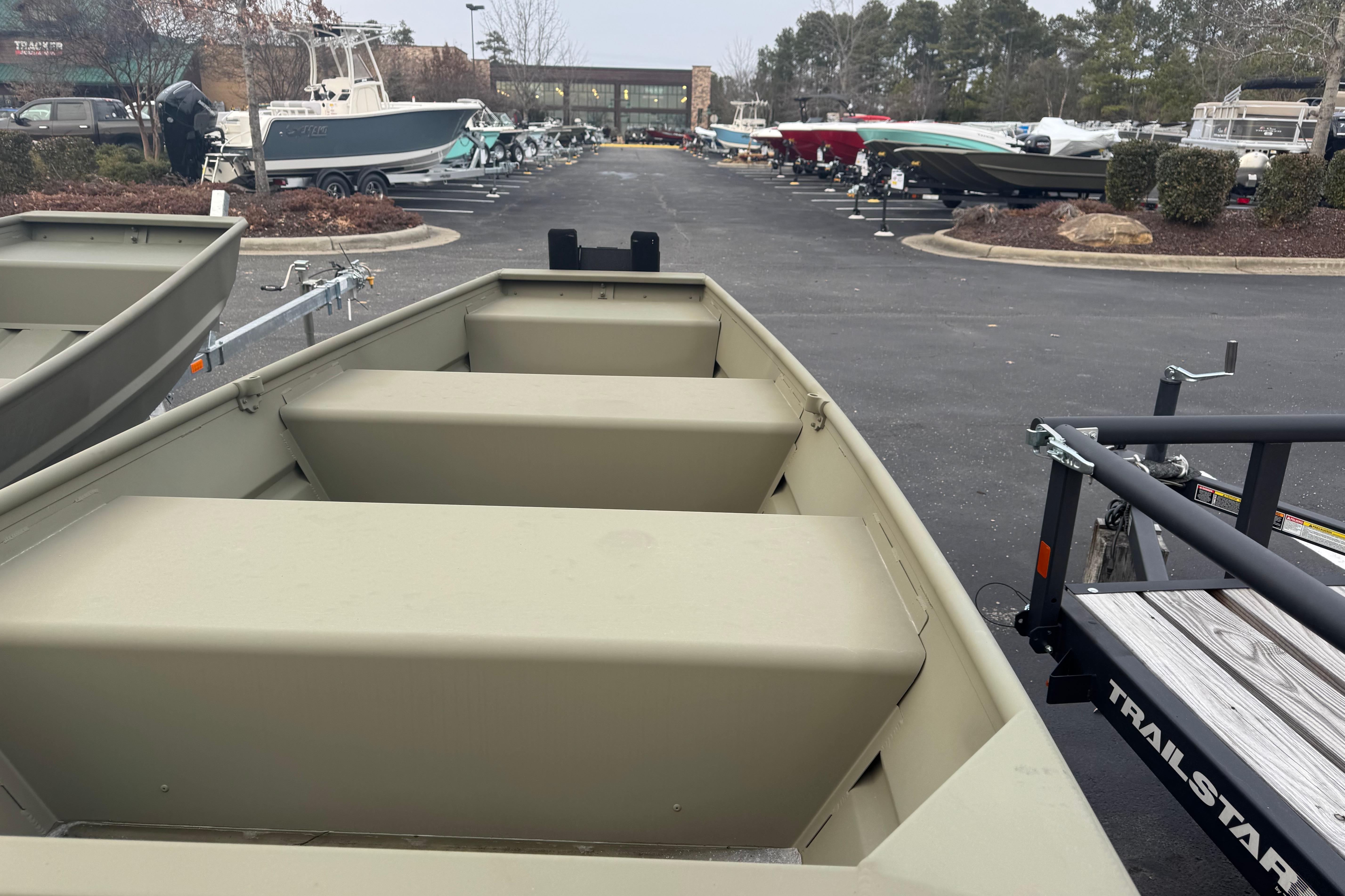 2026 Tracker Grizzly 10 Jon boat displayed in a dealership lot with various other boats.