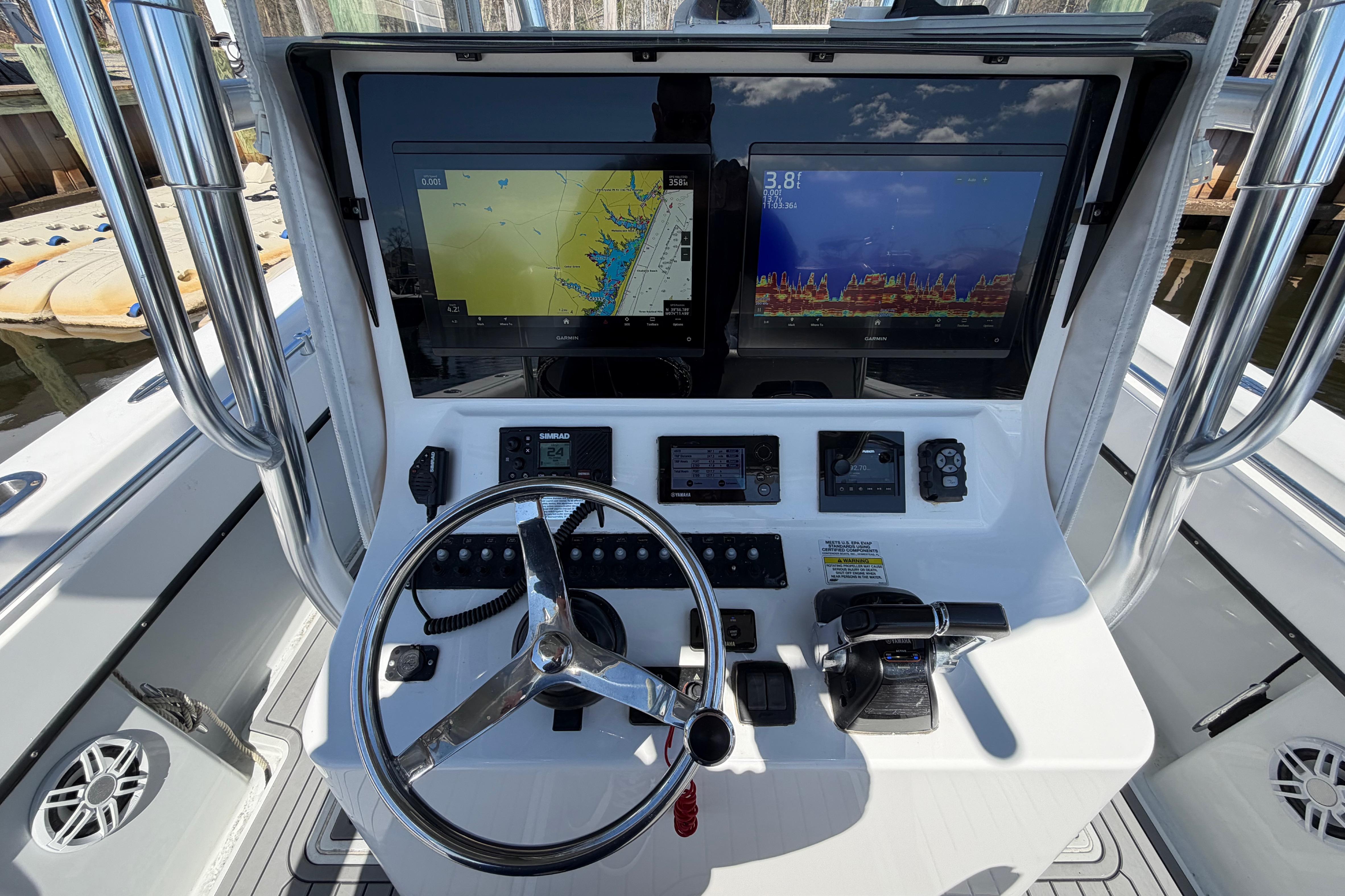 2015 Contender 32 ST boat dashboard with navigation screens and steering wheel.