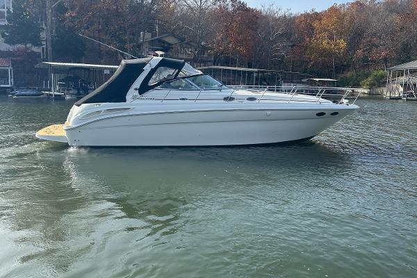 2004 Sea Ray 380 Sundancer yacht on a calm lake with autumn trees.