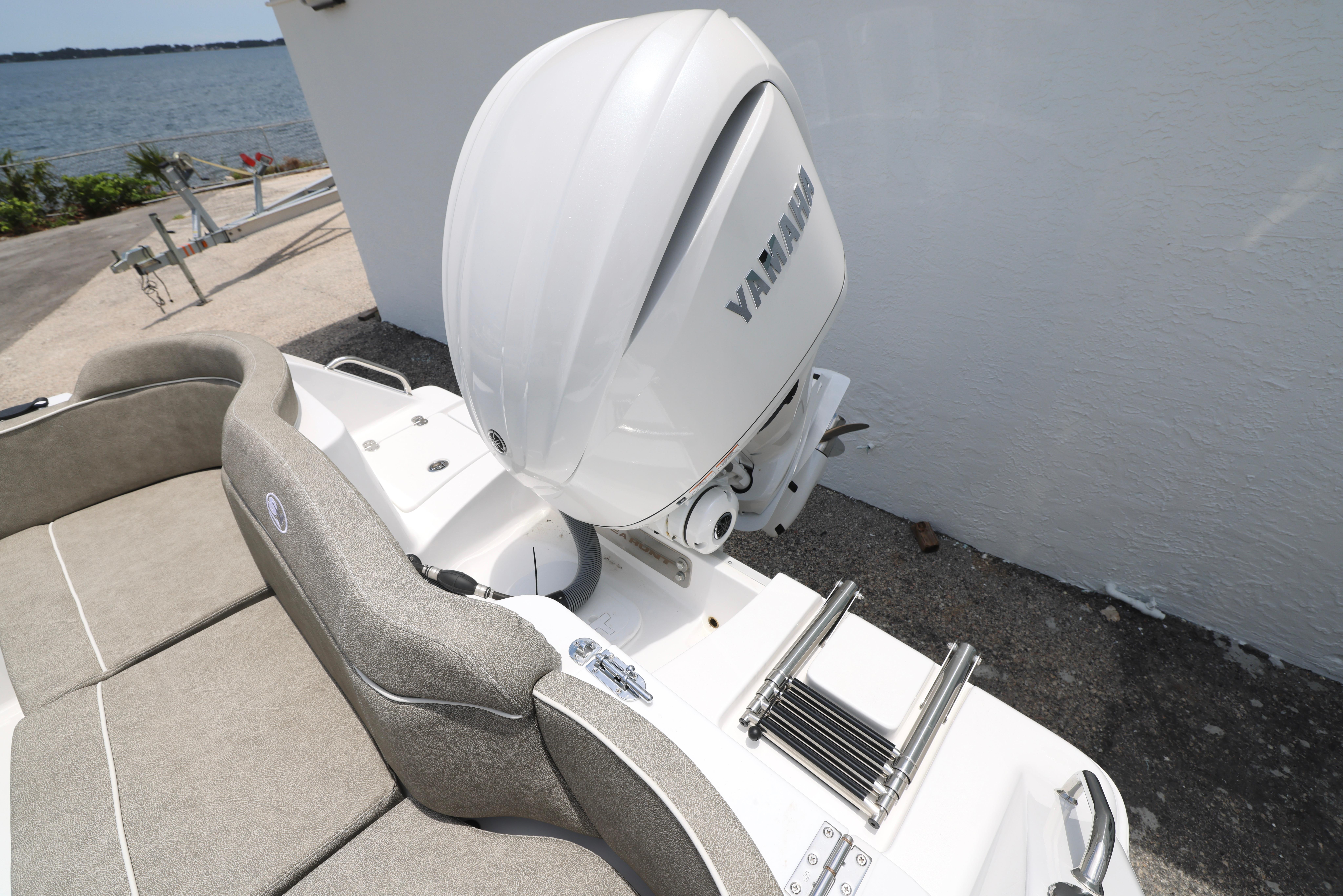 2026 Sea Hunt Ultra 245 SE boat with Yamaha outboard motor, docked by the water.