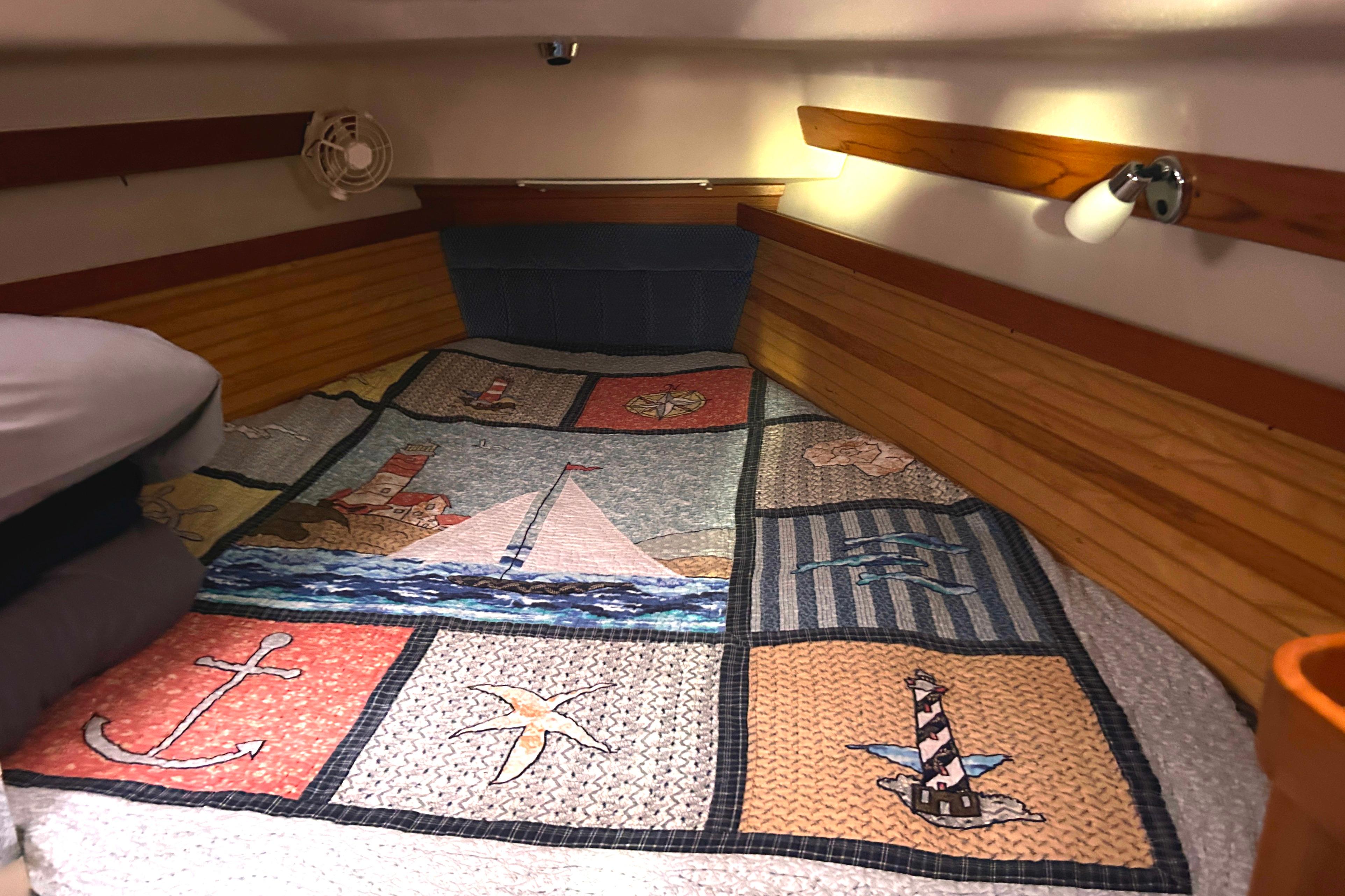 Cozy cabin interior of 2009 Catalina 375 sailboat with nautical-themed quilt.
