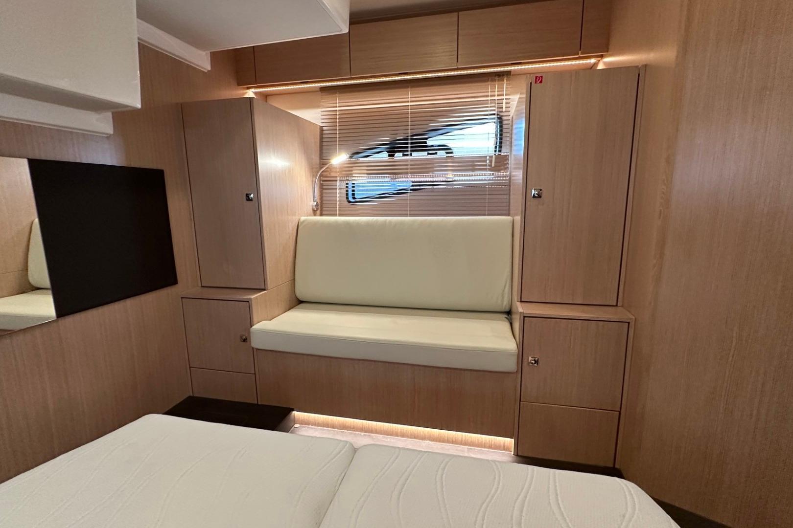 Luxurious interior of 2023 Bavaria SR41 yacht with wooden cabinetry and cushioned seating.