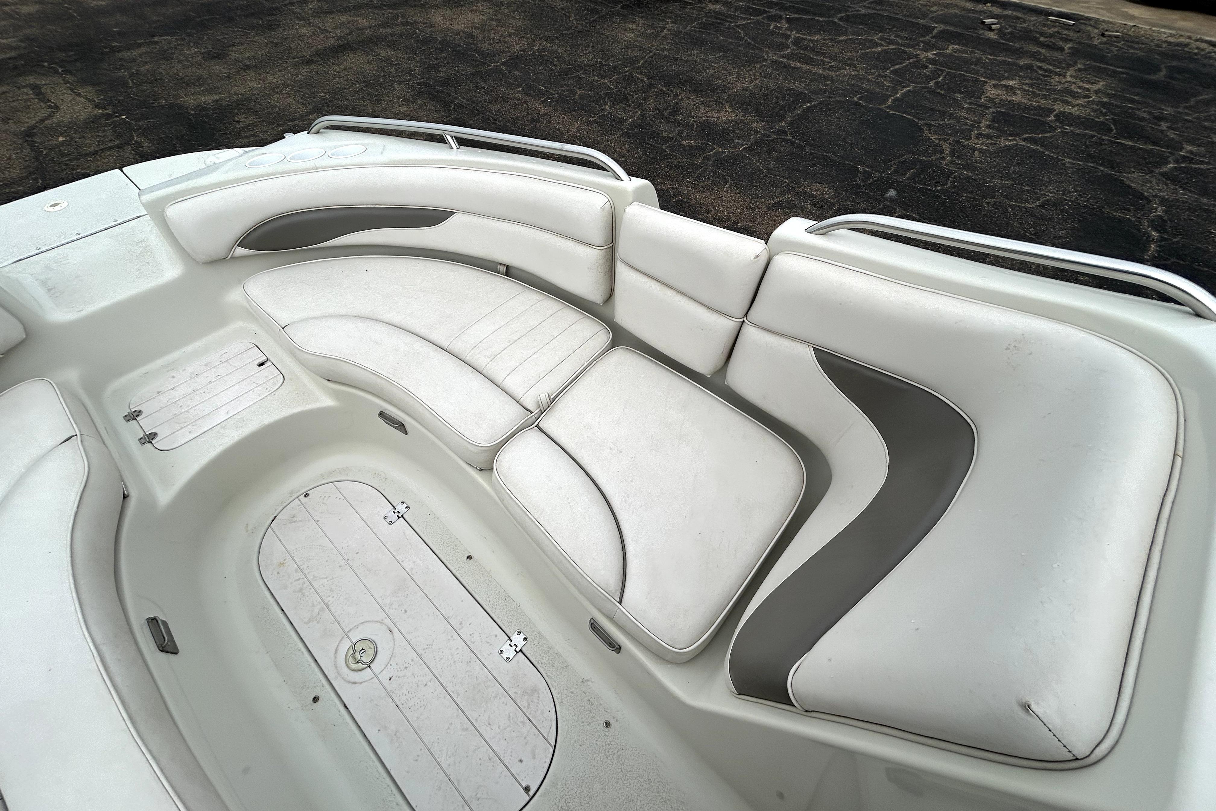 2001 Crownline 239 DB boat interior with white cushioned seating and storage compartments.