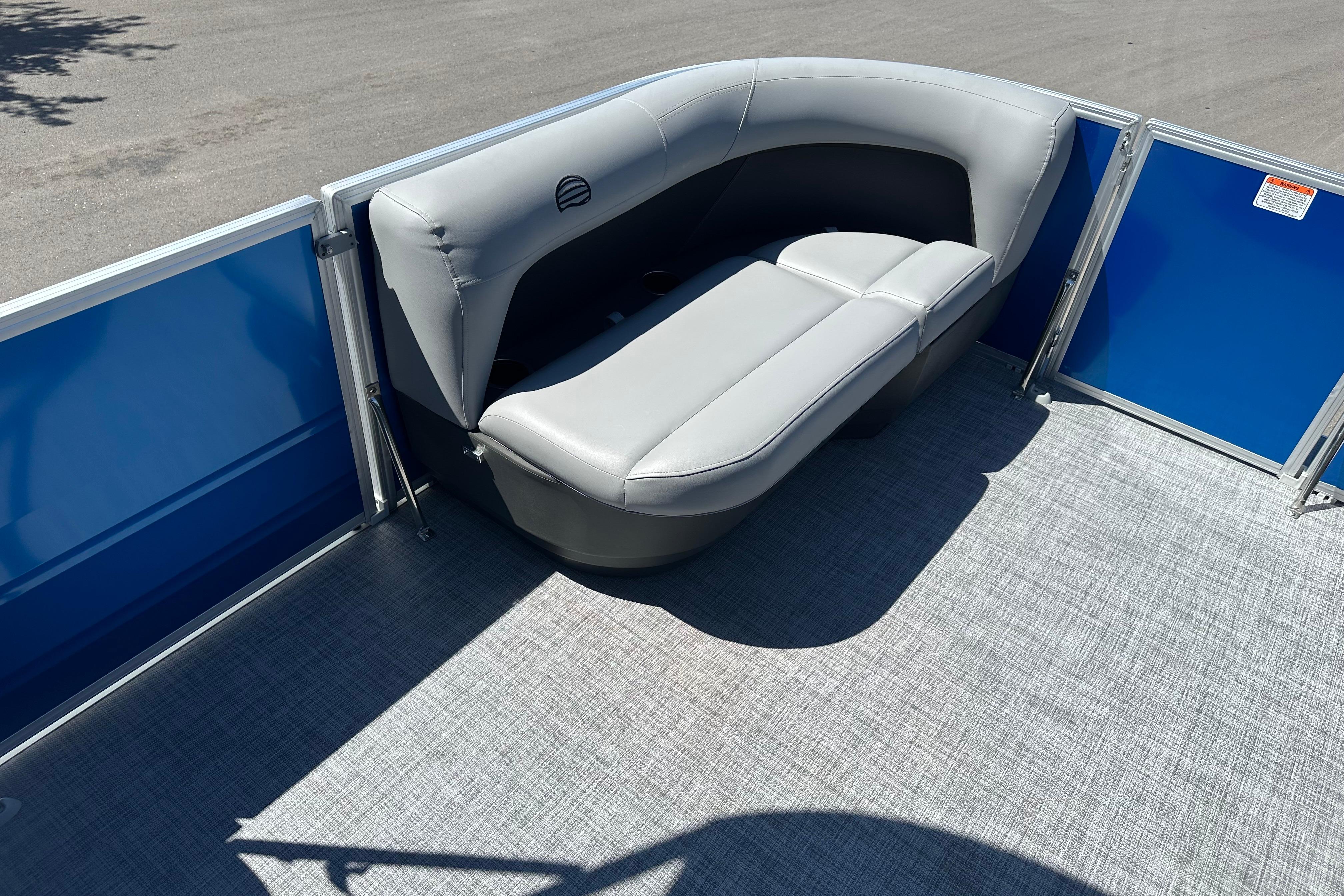 2026 Sun Tracker Party Barge 16 DLX with gray seating and blue paneling.