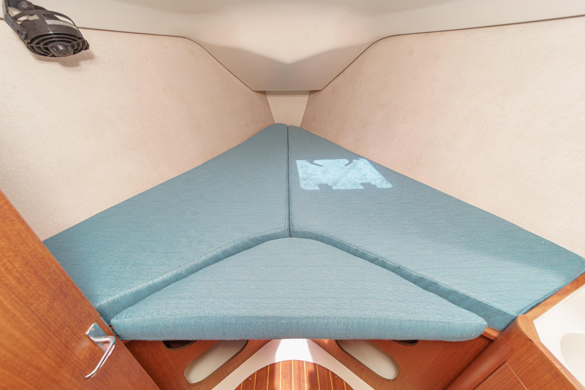 Interior cabin of a 1996 Hunter 376 sailboat with blue cushions.