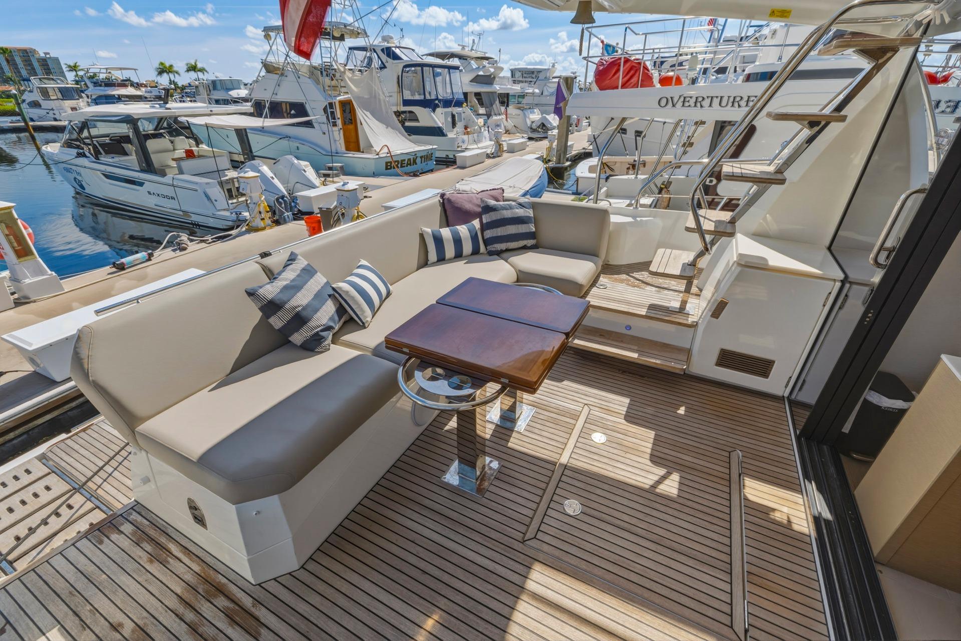 Luxurious 2022 Prestige 520 yacht deck with elegant seating and wooden flooring.