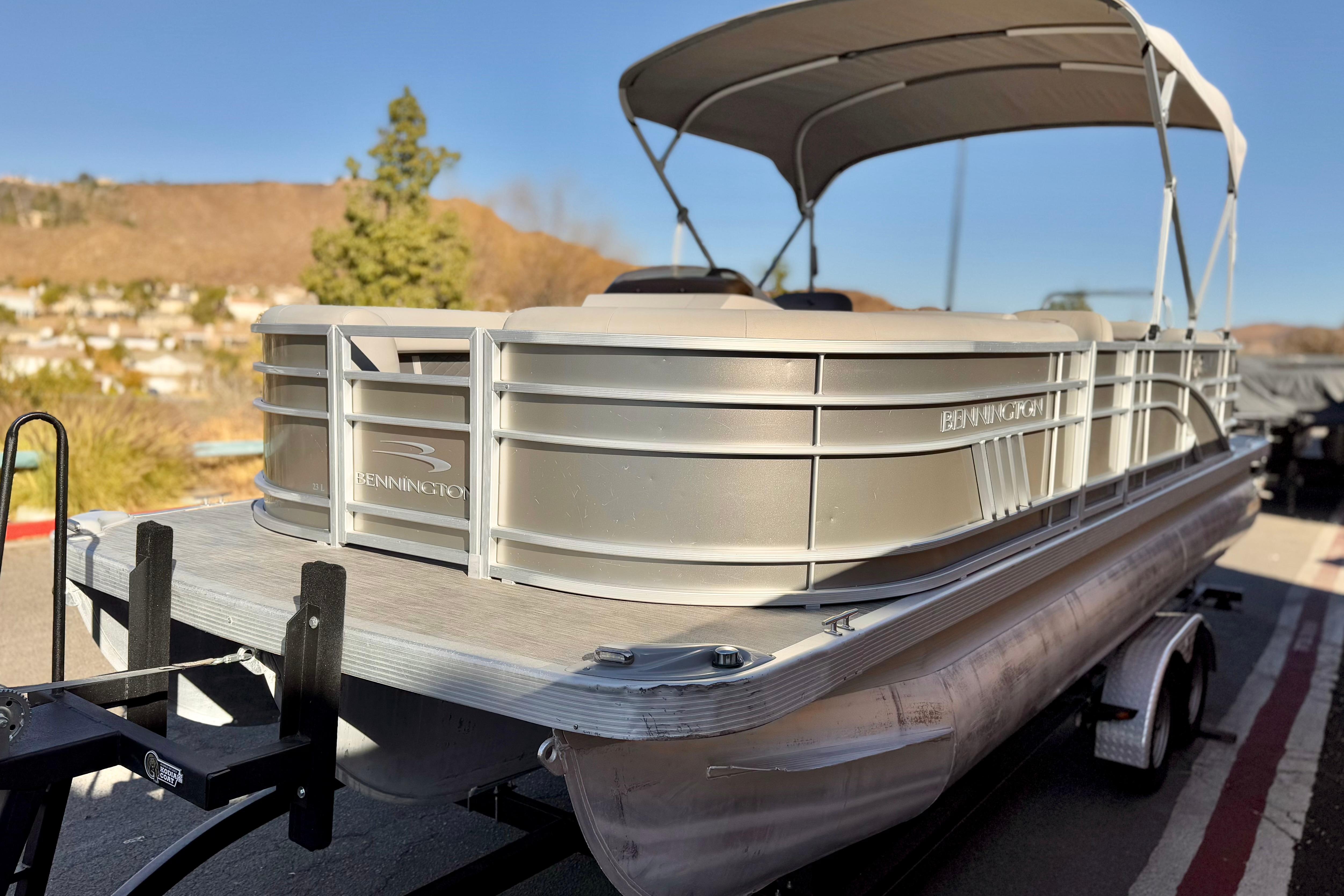 2021 Bennington 23LSR pontoon boat on trailer, featuring sleek design and canopy.