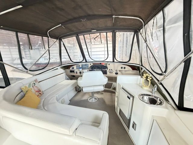 Interior of a 2005 Carver 44 Cockpit Motor Yacht with white seating and helm station.