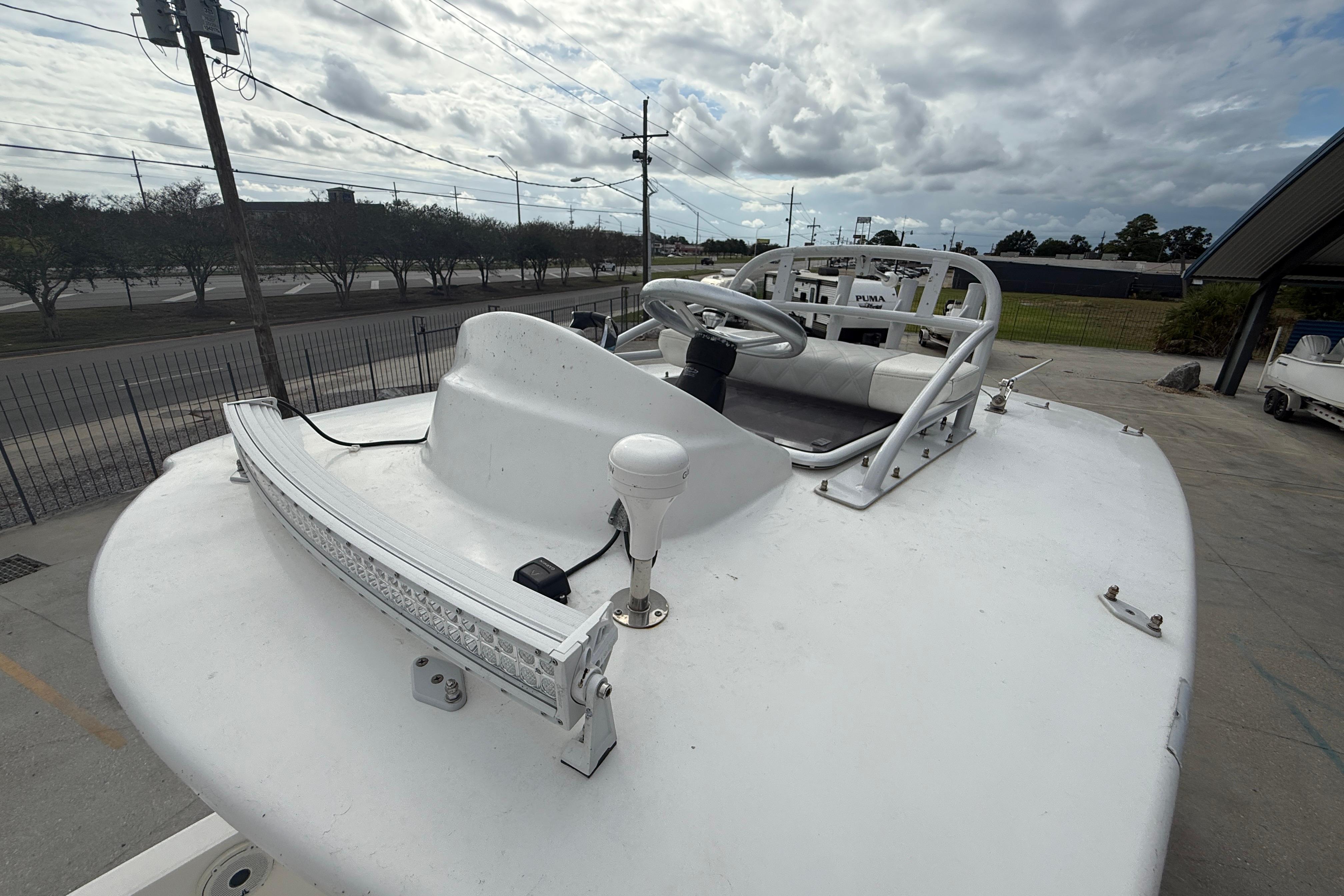 2021 Sea Cat 260 boat with steering wheel and light bar, parked outdoors under cloudy sky.