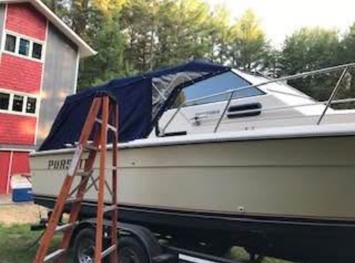 1984 Tiara Yachts PURSUIT 2600 on trailer beside red building.