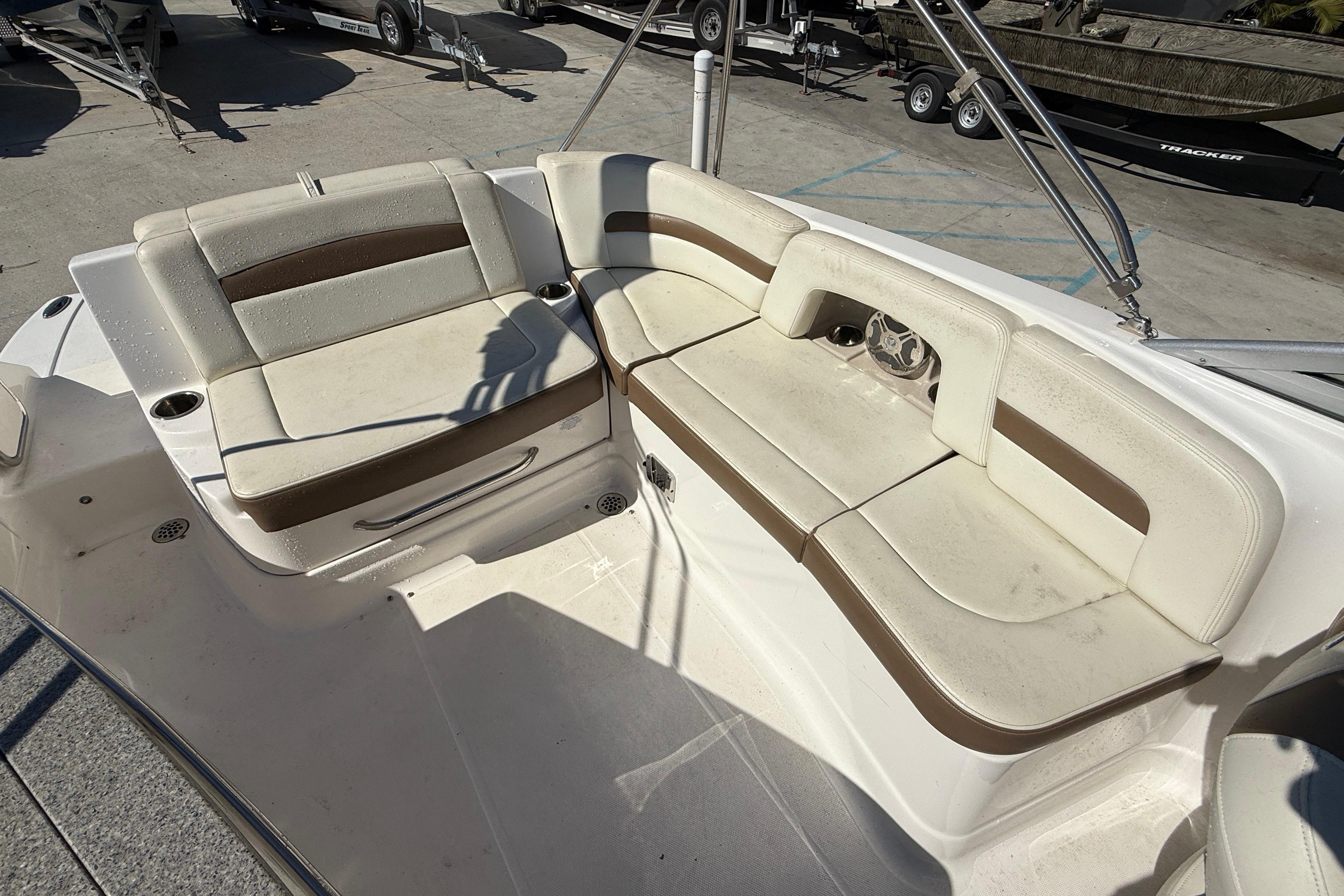2014 Chaparral 264 Sunesta boat interior with beige seating and cup holders.