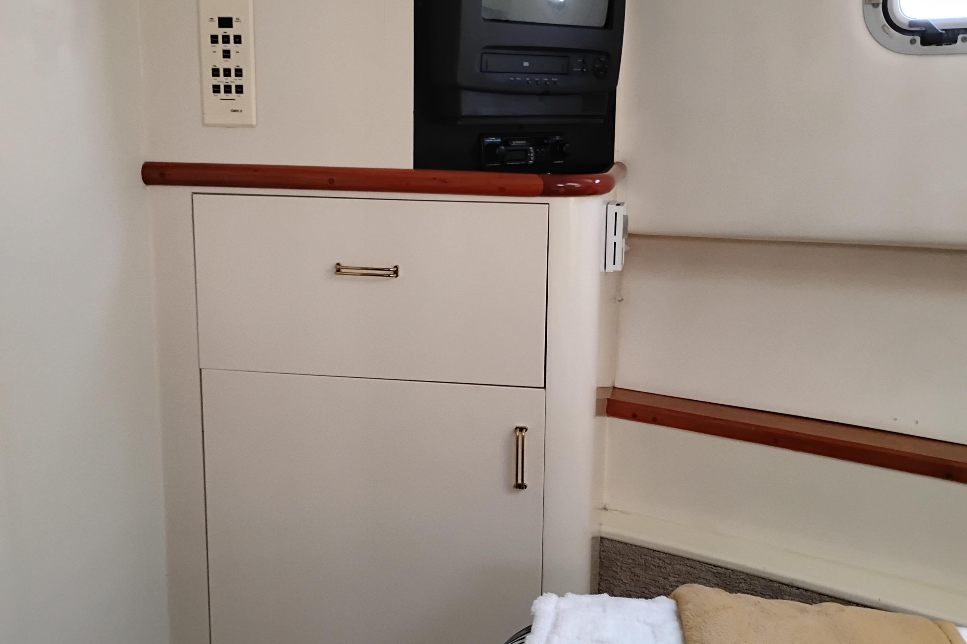 Interior of 1995 Queenship 62 Pilothouse Motor Yacht with cabinet and TV.