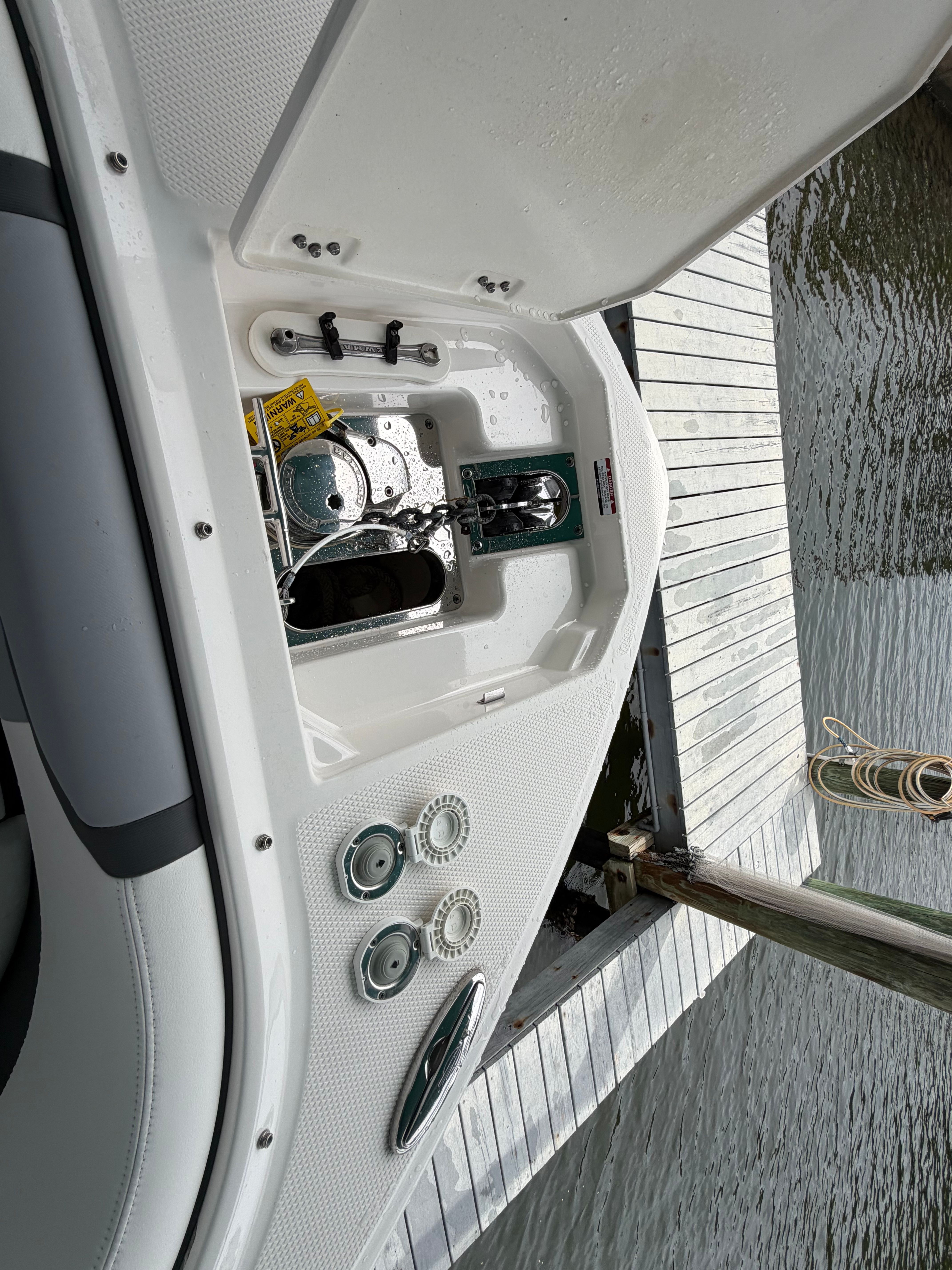 A boat is docked, showing an open storage compartment and visible controls.