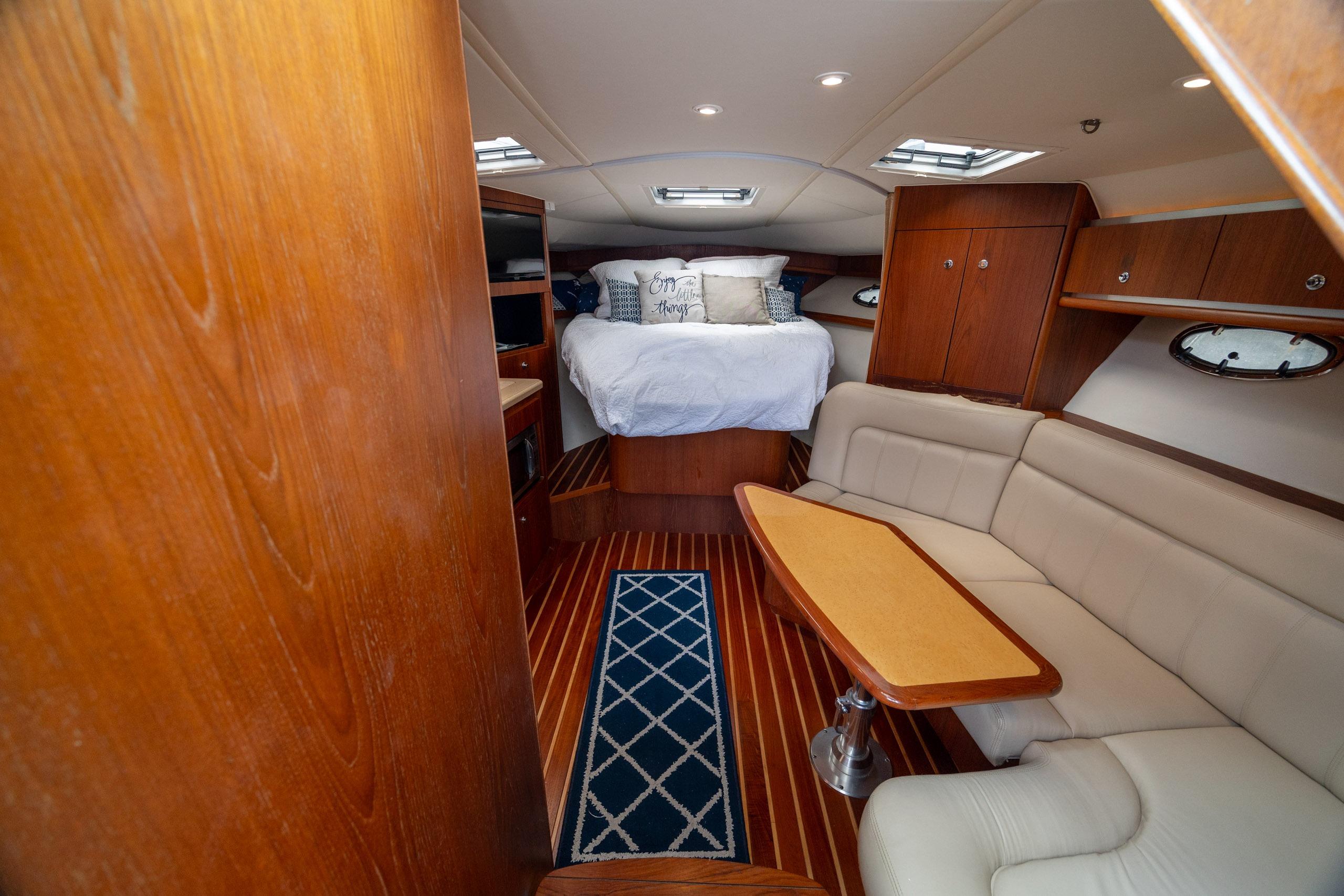 Luxurious interior of 2004 Tiara Yachts 3200 Open with cozy seating and elegant wood finishes.
