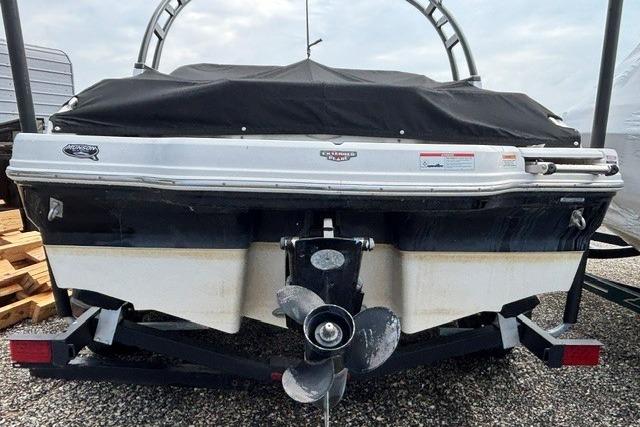Rear view of a 2021 Chaparral 21 SSi boat with a covered top and visible propeller.
