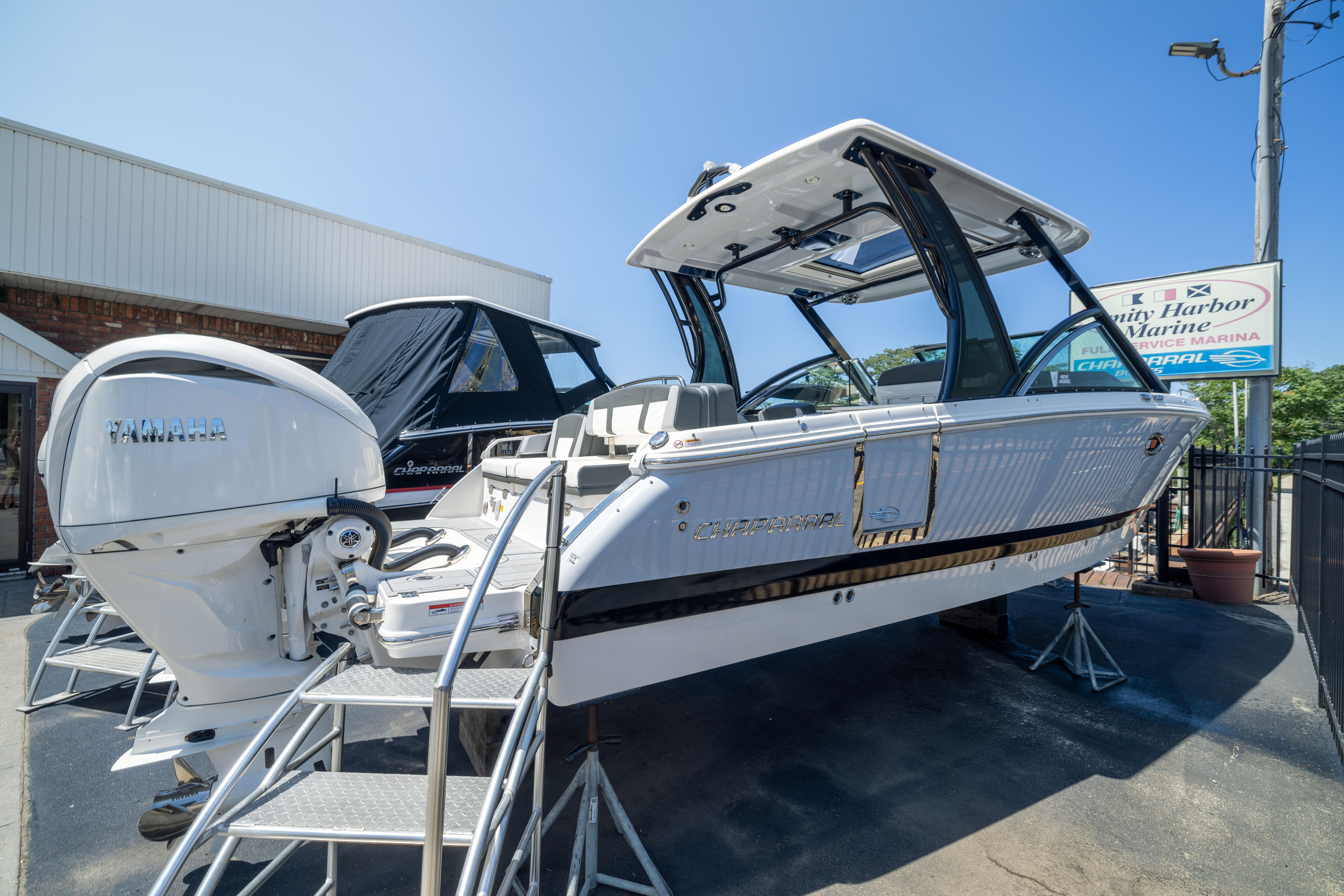 2026 Chaparral 310 OSX boat displayed at a marina with Yamaha engine.