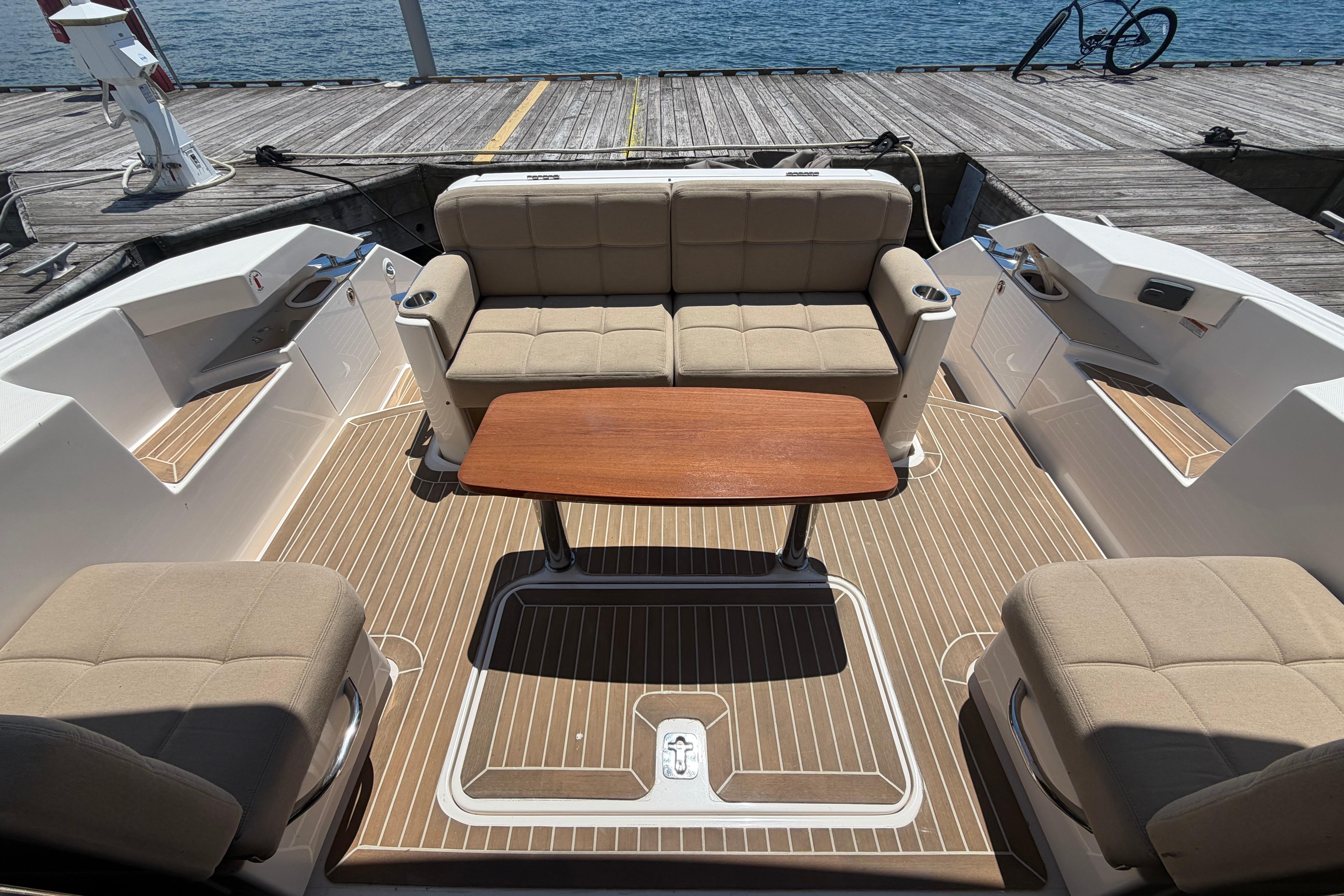 2016 Tiara Yachts C39 Coupe interior with seating and wooden table, dockside view.