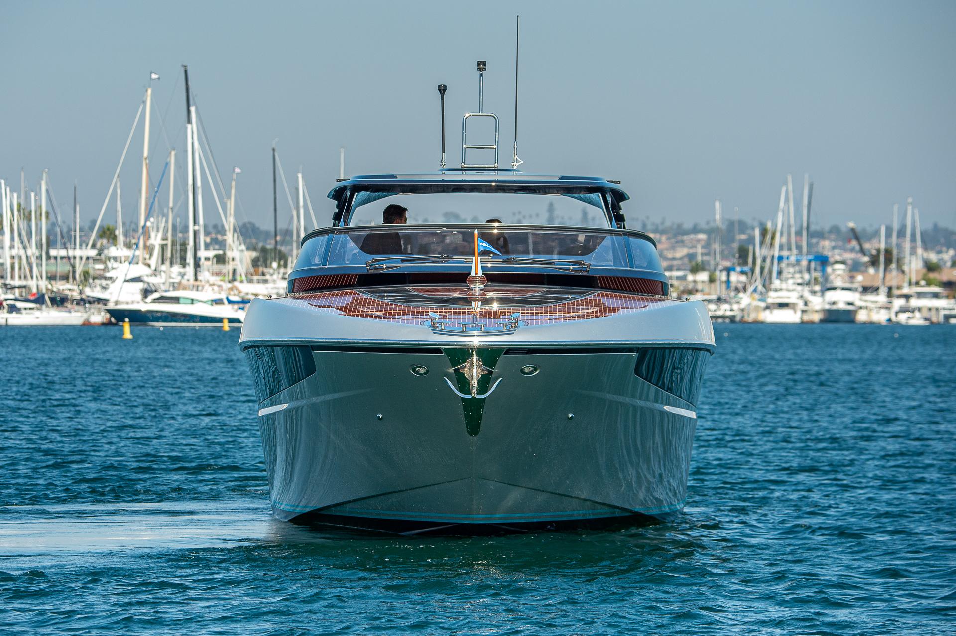 2024 Riva 48 Dolceriva yacht cruising in a marina with sailboats in the background.